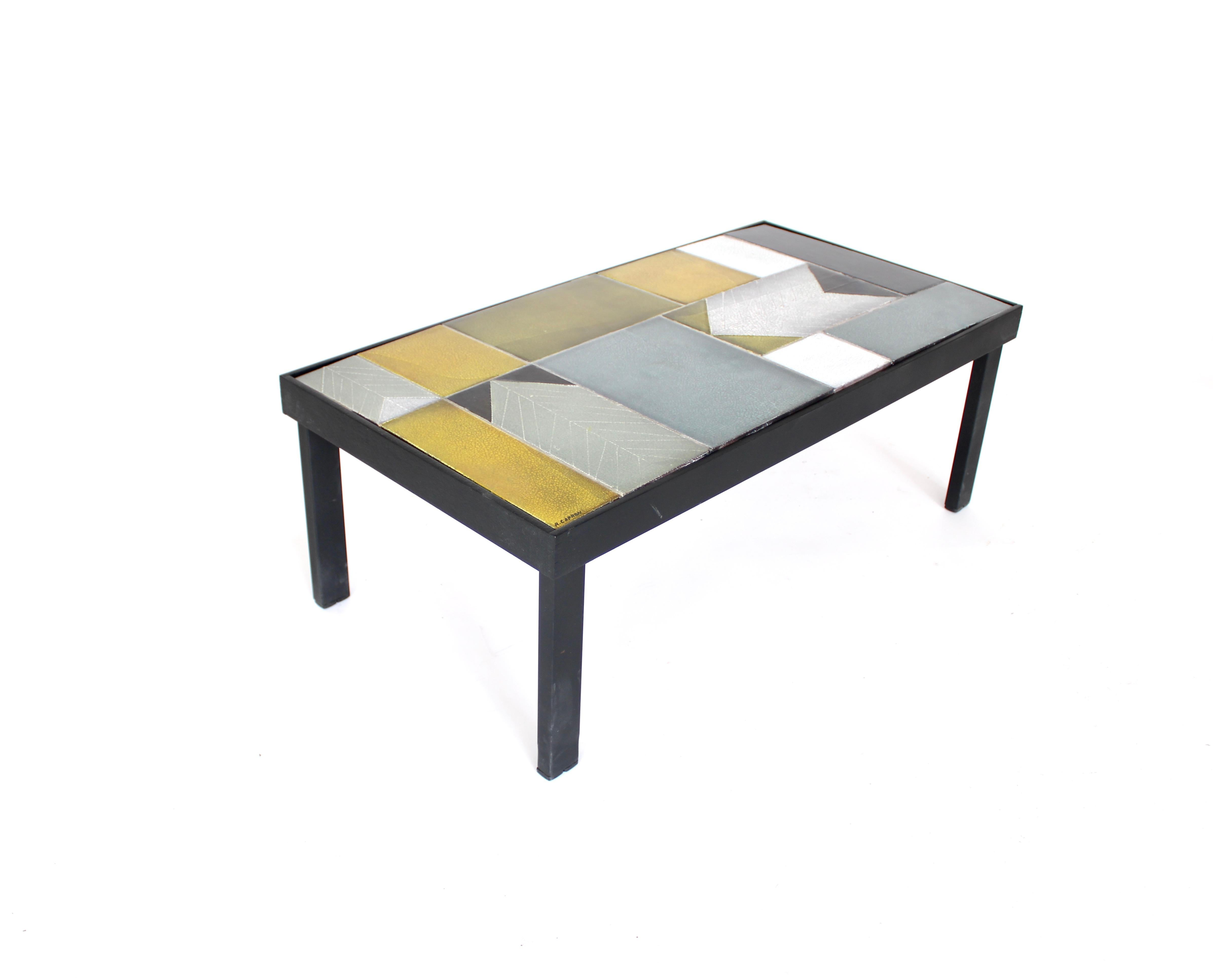 Table basse en carreaux de céramique de Roger Capron, au design abstrait et à la disposition des carreaux. 
Ce style, souvent pratiqué par Capron dans les années 60, était moins littéral et plus abstrait. L'utilisation de la couleur est très