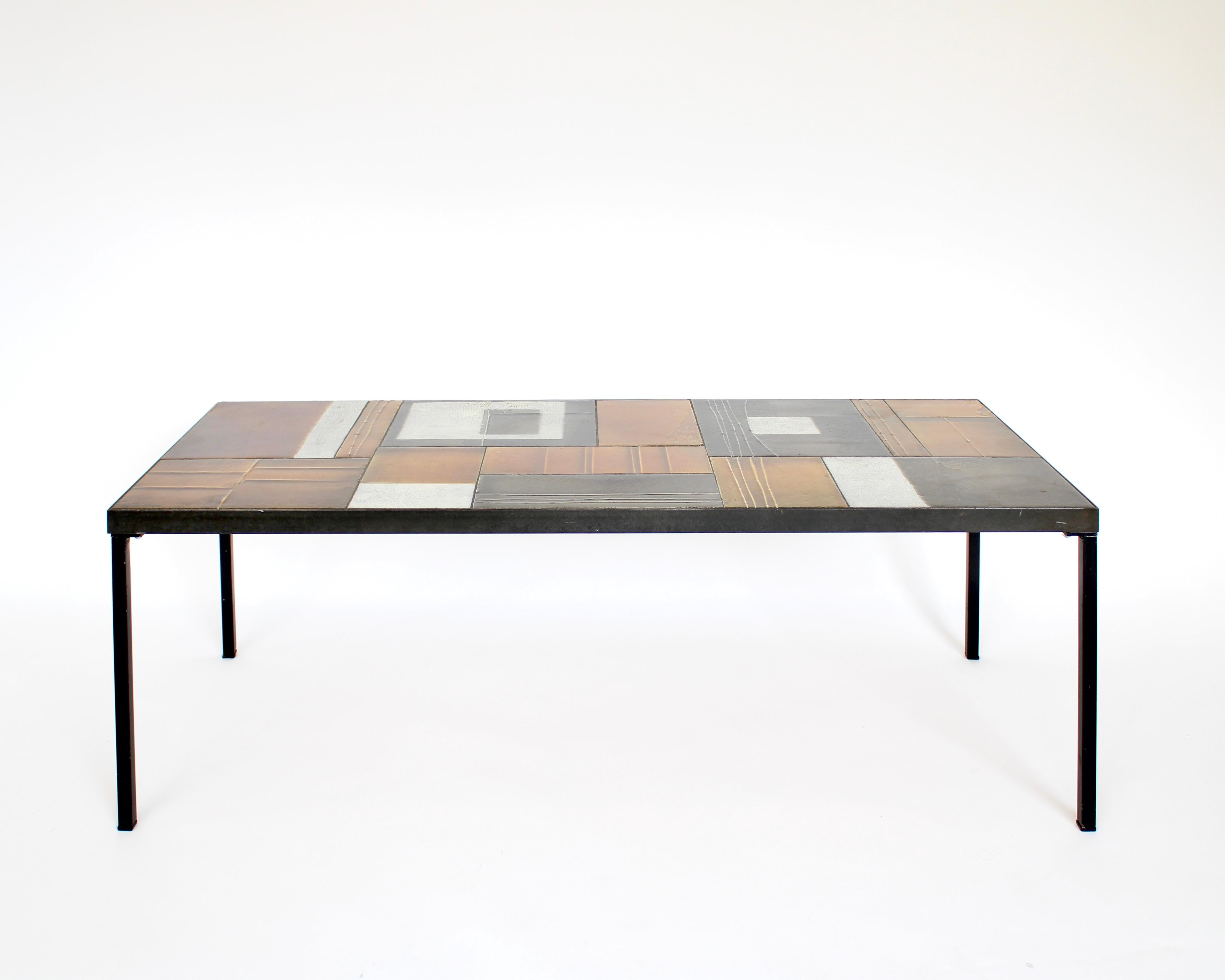 Roger Capron ceramic tiled coffee table in an abstract design and arrangement of the tiles. 
This style was often done by Capron during the 60's which was less literal and more abstract. The use of color is very different than the previous more