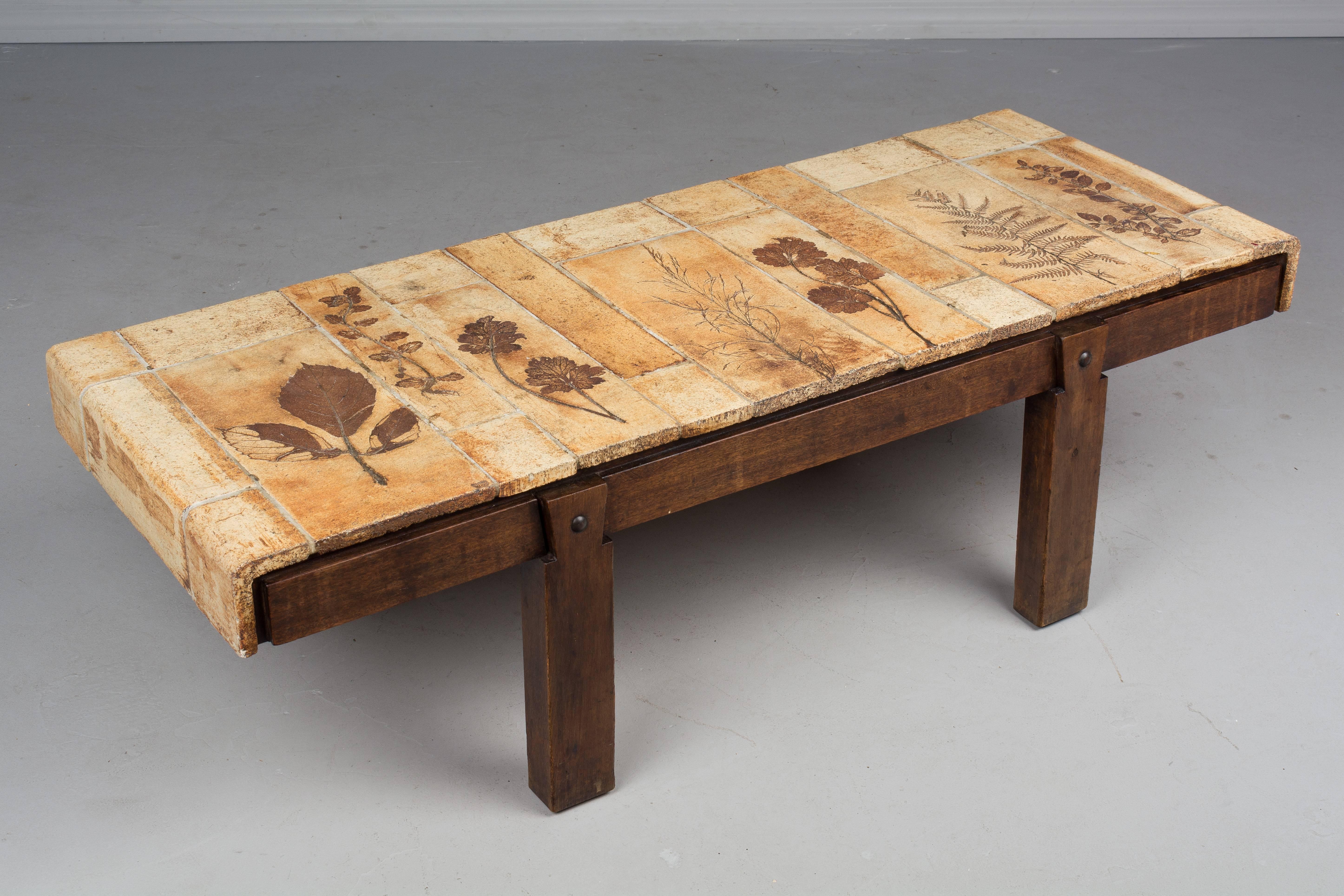A Roger Capron coffee table from his Gariggue series with a solid oak base and a top made of finely crafted earthenware ceramic tiles imprinted with the fossils of various plant specimens. Garrigue refers to the vegetation that grows wild on the