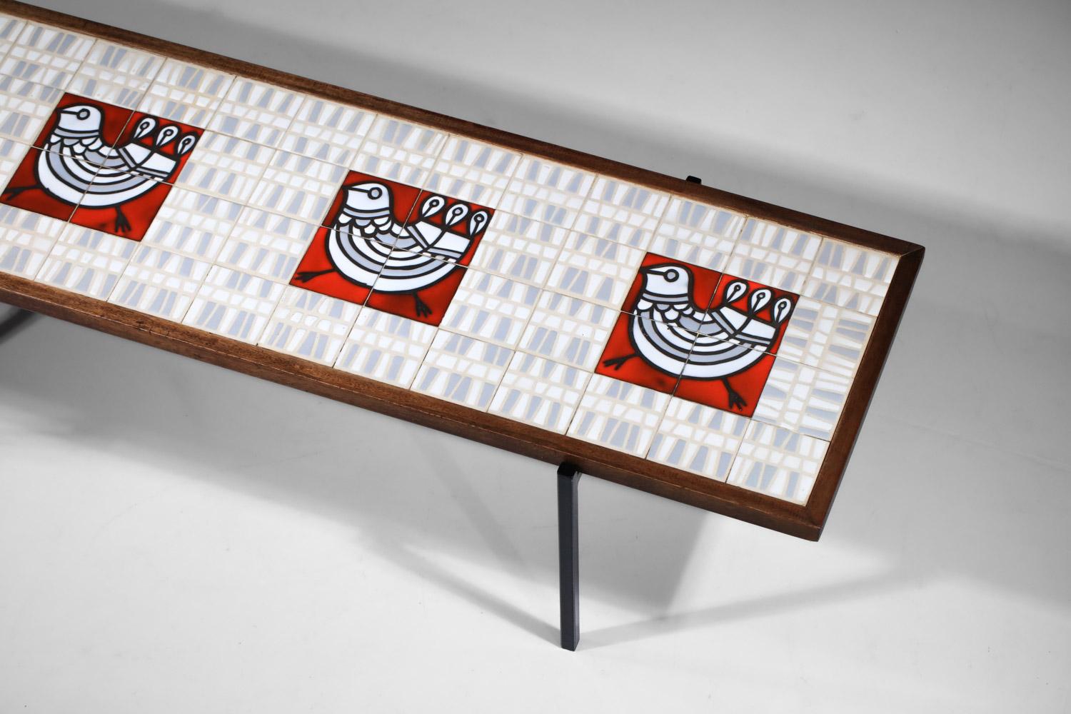 Table basse des années 1950 du céramiste français Roger Capron de Vallauris. Le plateau est en chêne massif et la base est en métal peint. Le plateau est entièrement constitué de carreaux de céramique avec un motif géométrique représentant trois