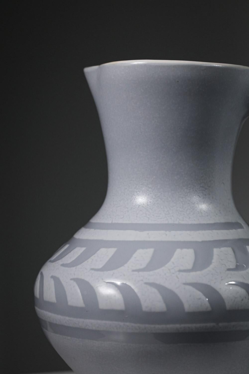 Großer Keramikkrug oder Vase von Roger Capron aus den 60er Jahren. Emaillierung in hellgrauen und weißen Farbtönen. Nüchternes und reines Design, verziert mit einem Fries rund um die Vase. Sehr schöner Vintage-Zustand, Signatur des Künstlers unter
