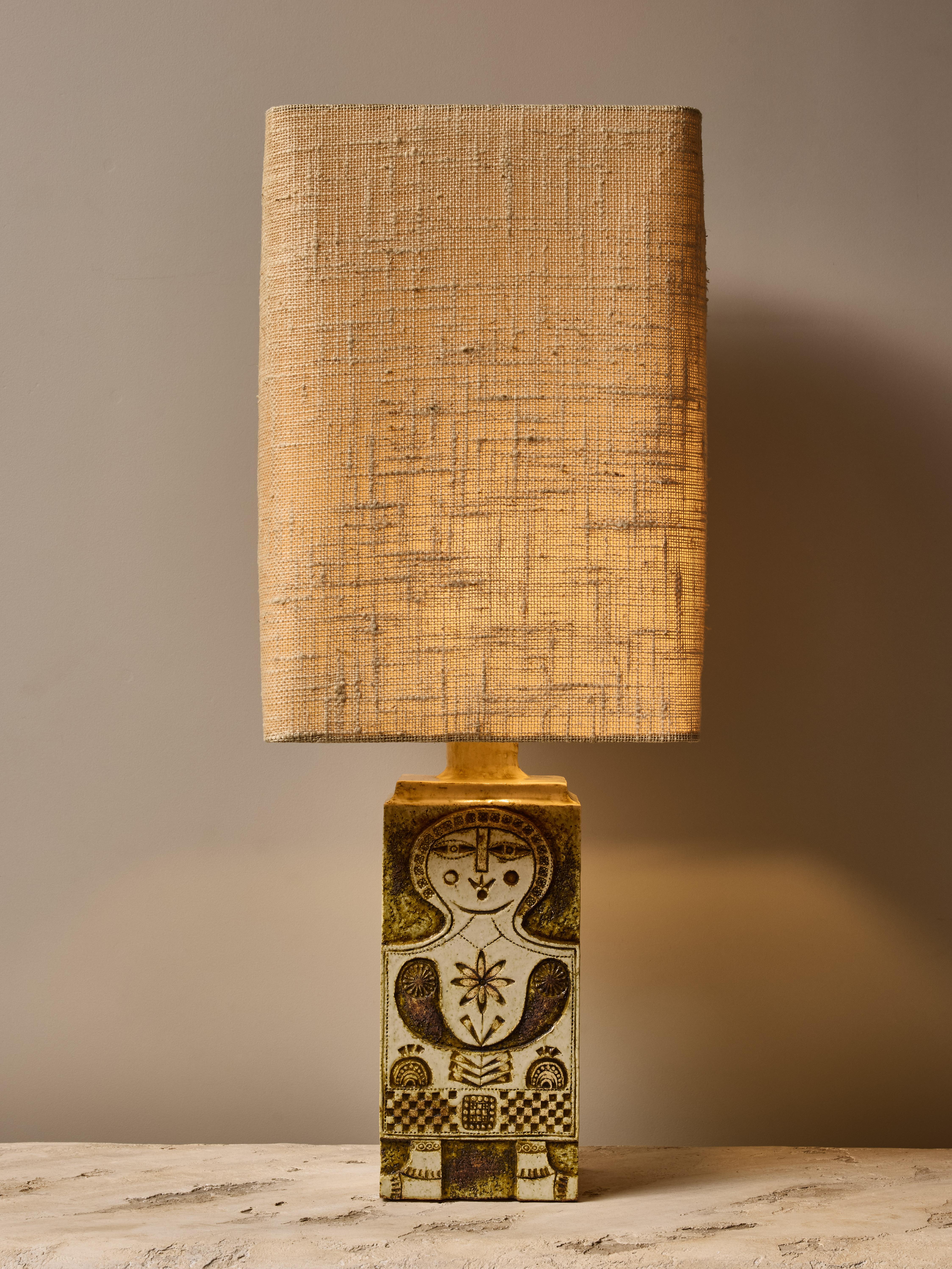 Stunning table lamp made by Roger Capron, made of a square base with a character decor on the front face.

 Artist’s stamp on the bottom back of the lamp “Capron Valloris France”.
Topped with its original vintage lampshade.

Dimensions with