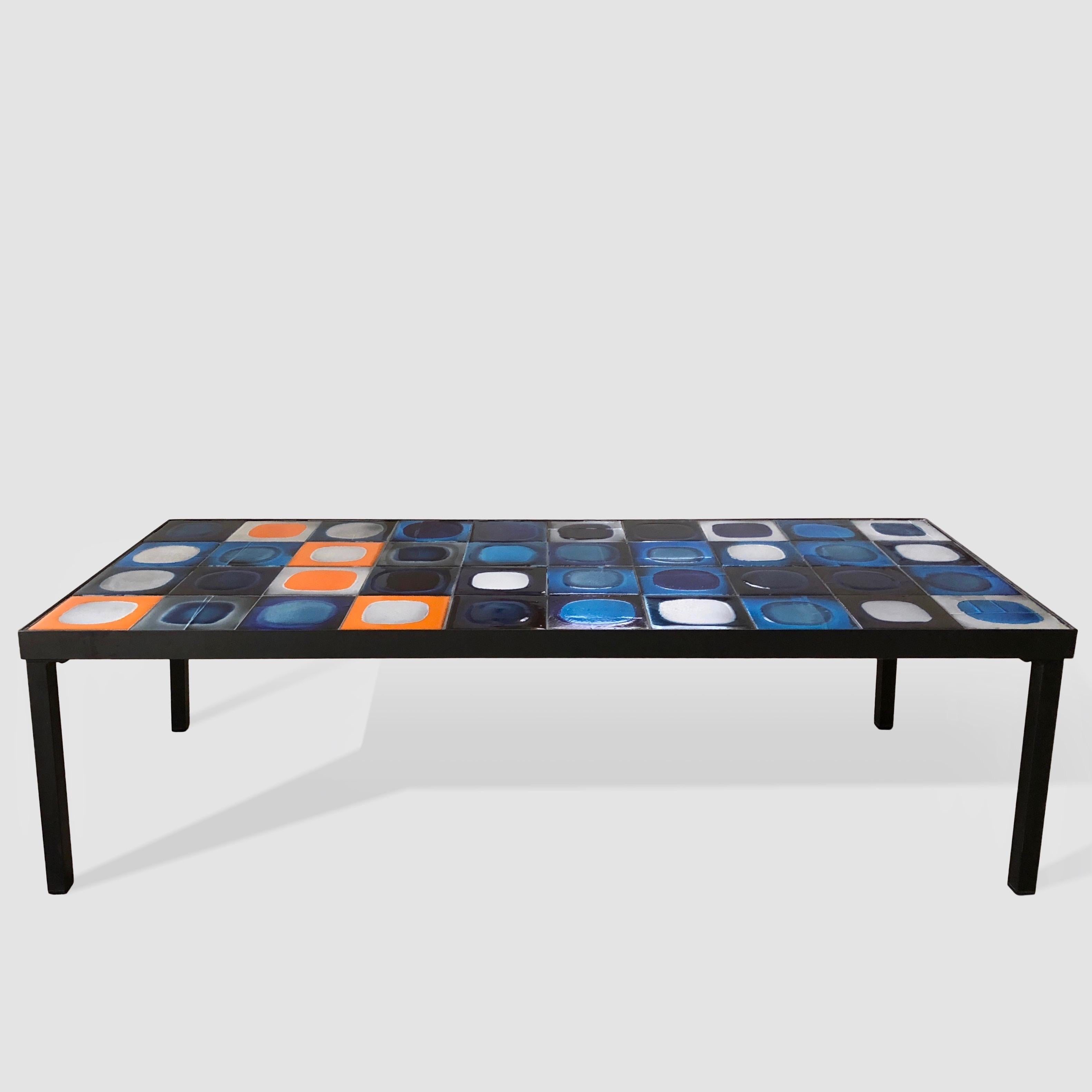 Glazed ceramic tiles table top coffee table on black metal frame and legs.
Mid-20th century model designed by the French artist Roger Capron.

Model named planètes (planets) with rare ceramic tiles glazed in shiny and matte tons of blue, white, grey