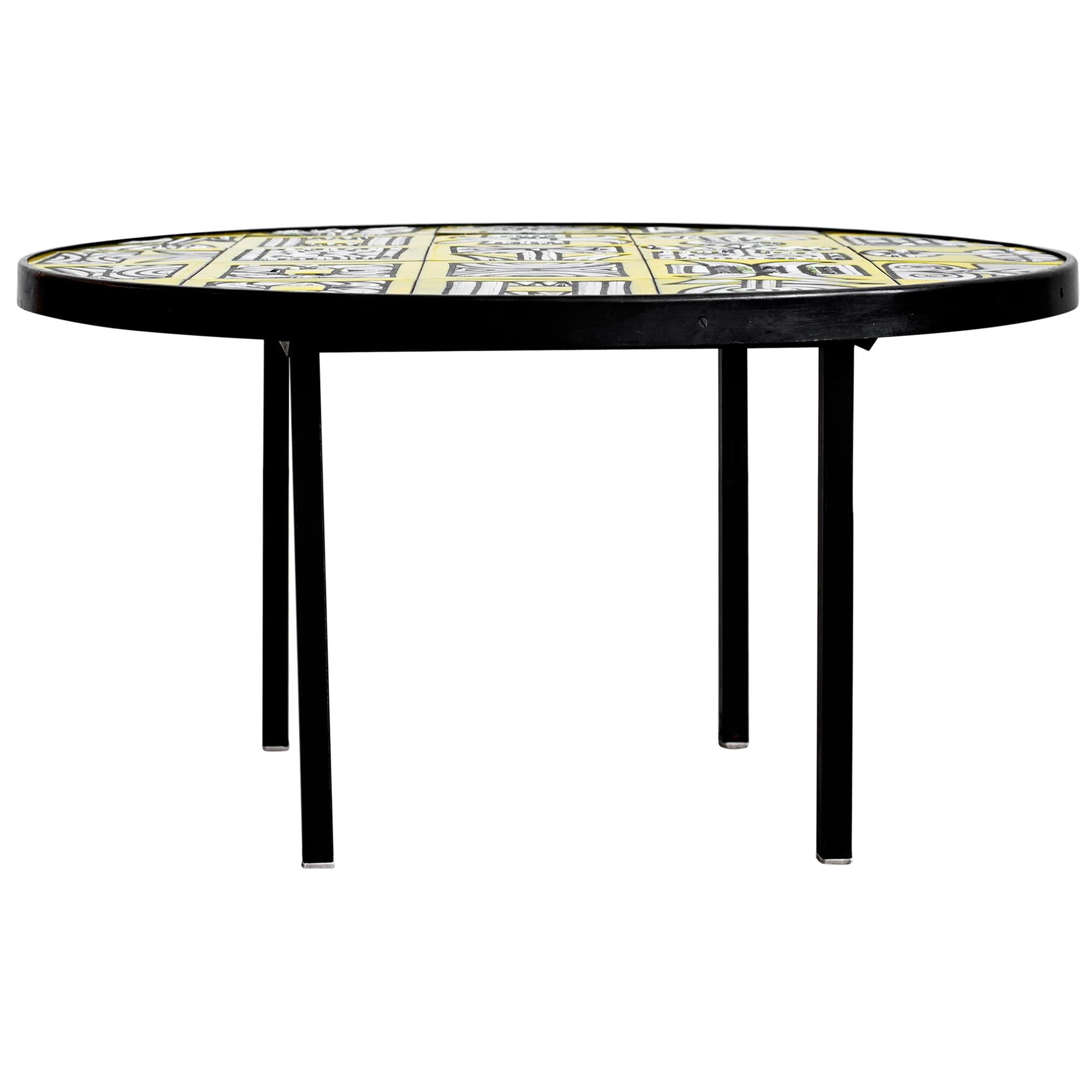 Fantastic round coffee table by Roger Capron. Beautiful bright yellow tiles feature geometric and whimsical designs on surface. Low profile with metal legs. Two small corner chips on tiles. See photos.