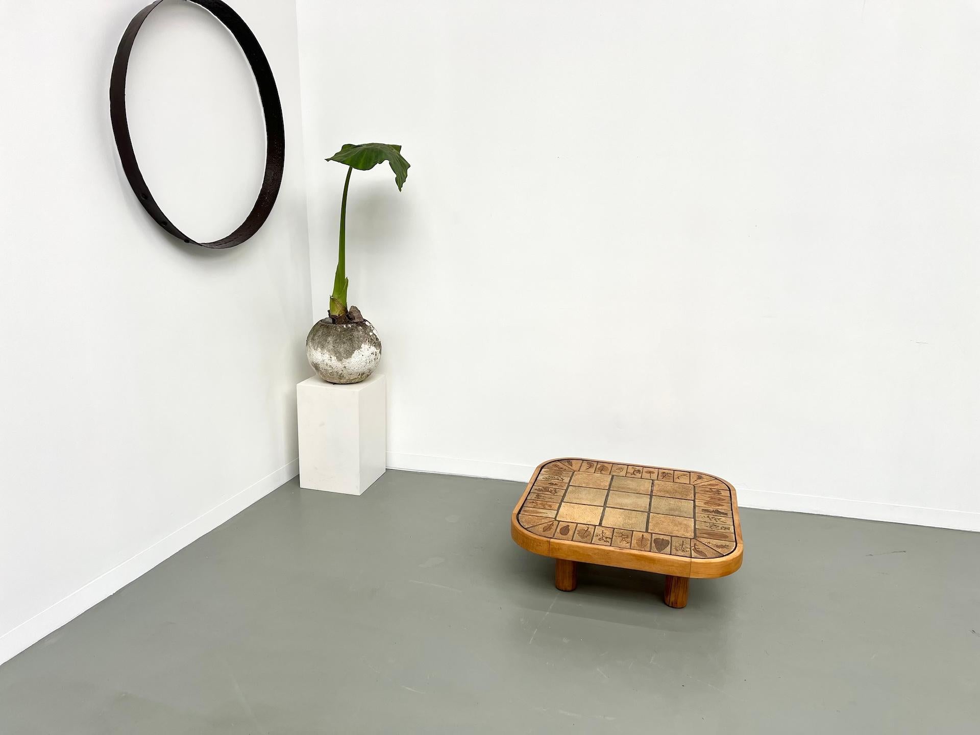 Ceramic coffee table with solid beech legs from the 1970s. This square model with its seagrass motif is rare, and the honey beech finish is even rarer. A beautiful piece combining French craftsmanship with Vallauris ceramics and a modernist