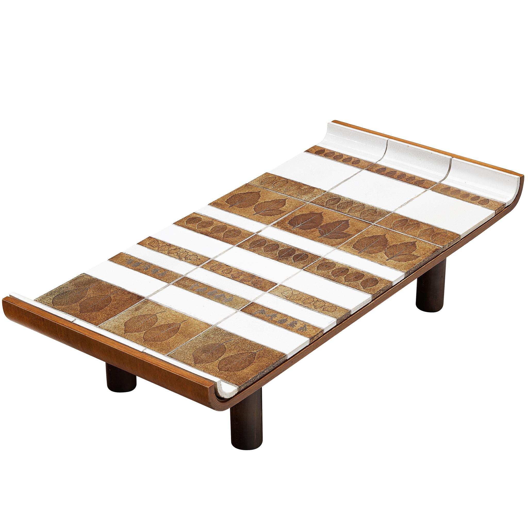 Table basse Roger Capron aux bords arrondis et ornée de motifs illustrés en céramique
