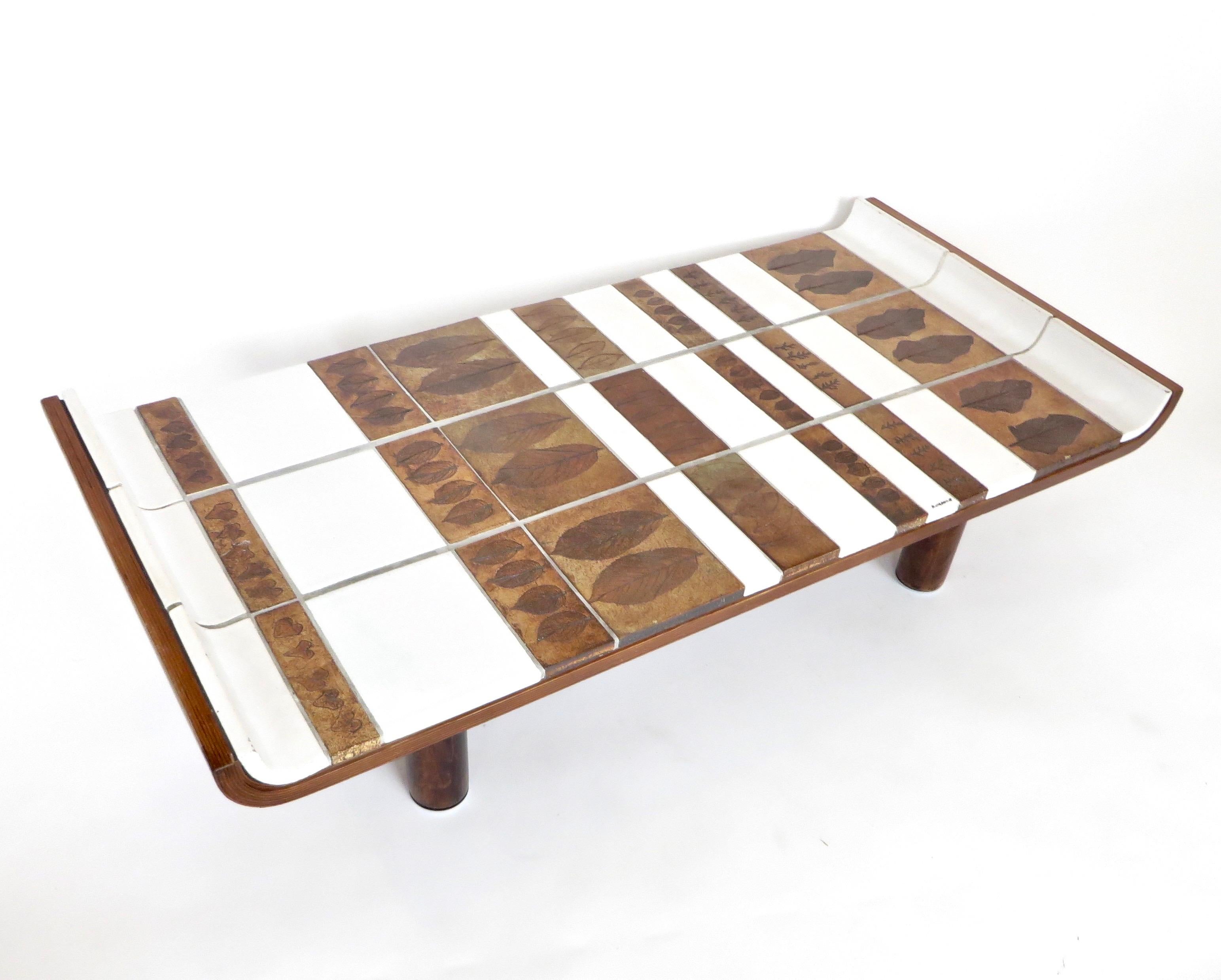 Roger Capron Pagode or Fuji model ceramic coffee table, circa 1960. Vallauris, France.
Oak frame supporting white glazed tiles and tones of brown ceramic tiles with impressed leaves in the ceramic in the iconic impressed leaf series of Roger Capron