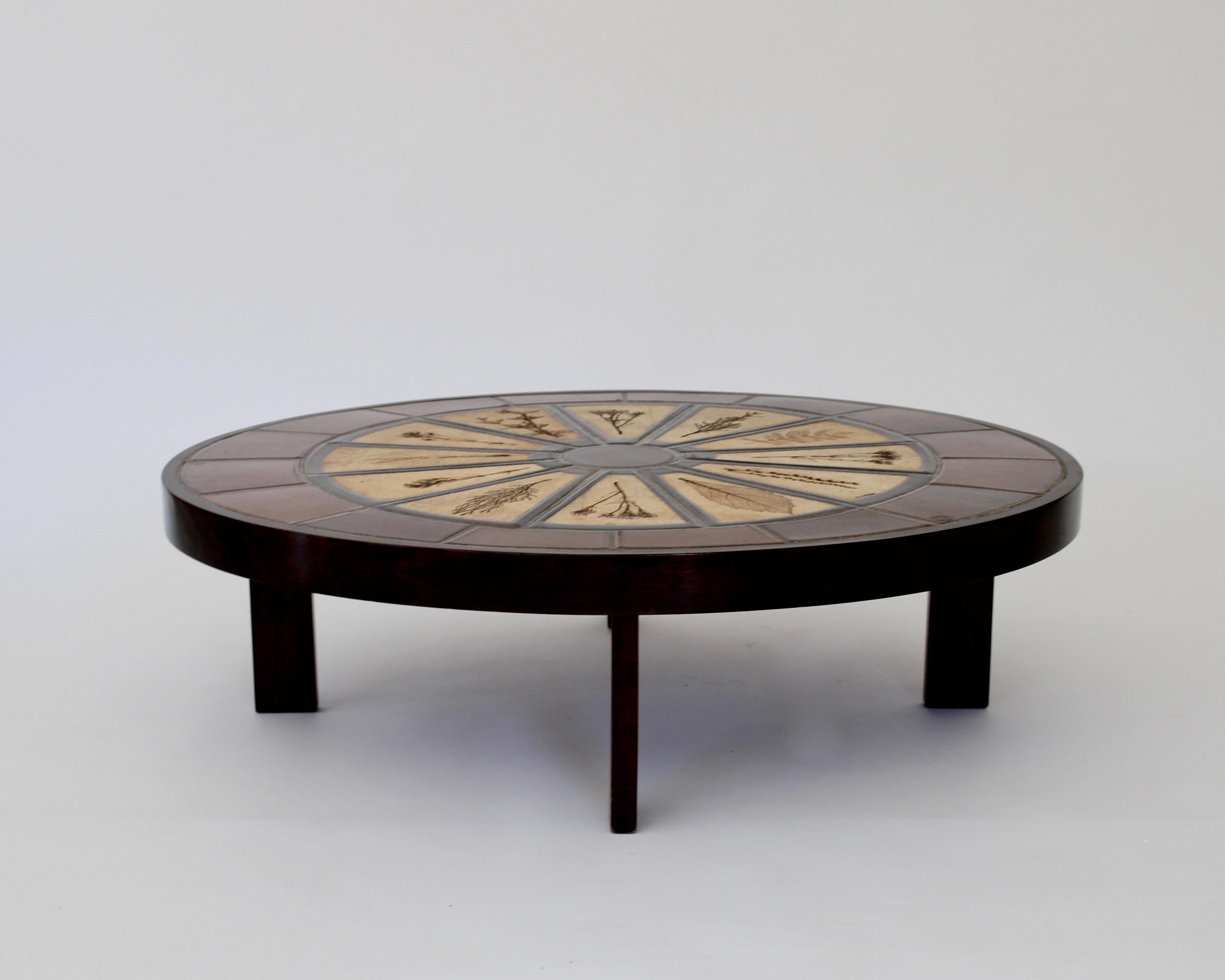 Roger Capron ceramic coffee table with impressed leaf decorations. The leaves are from the surrounding woods and gardens of Vallauris where Capron had his studio. 
The table is more oval than completely round. 
Signed R Capron
No chips or cracks