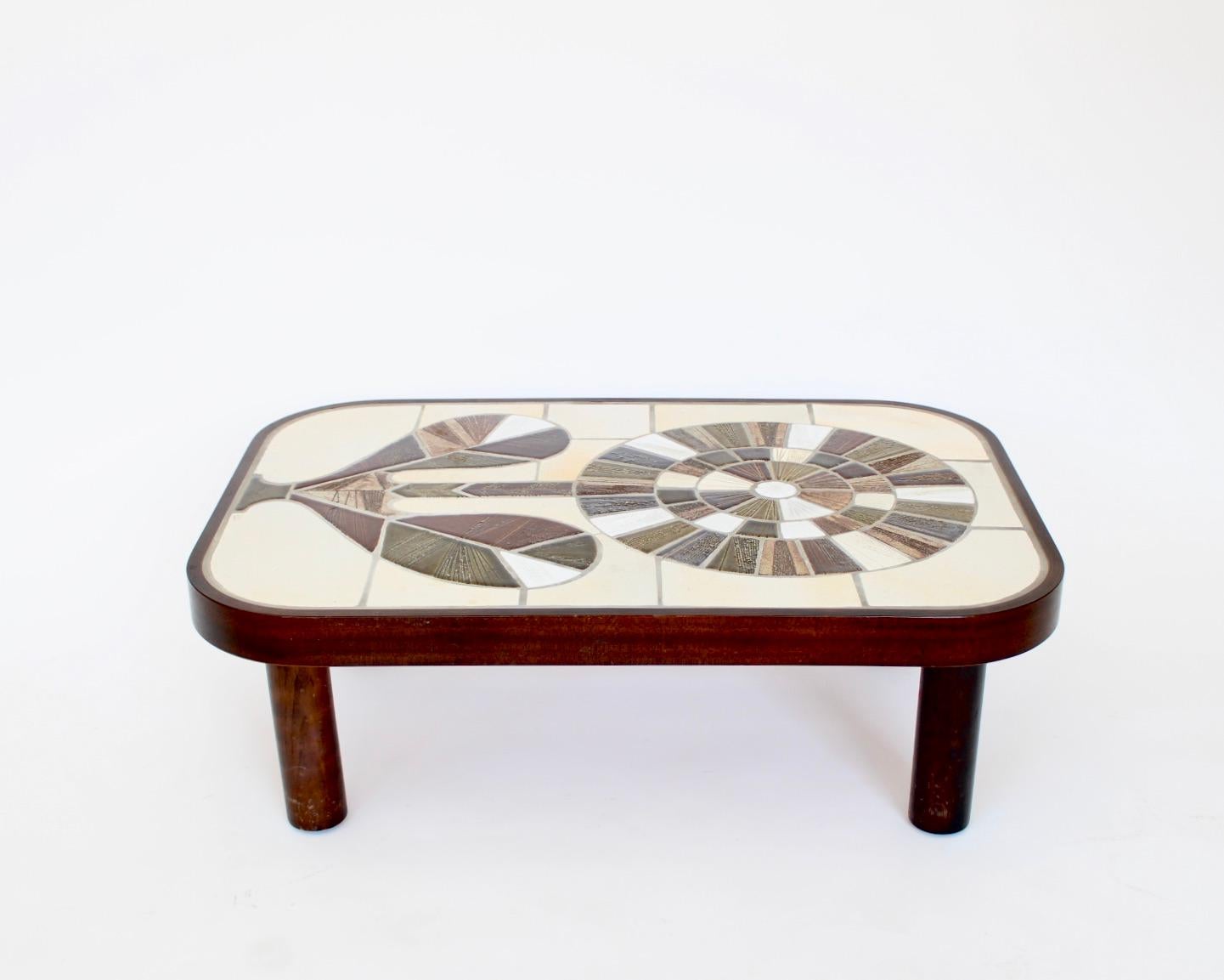 Roger Capron French ceramic handmade tiled coffee table with a vibrant radiating sunflower motif. 
Colors of olive green and shades of olive green and brown, tan, beige and white. 
All the grouting is in place. The wood frame has a dark stain and is