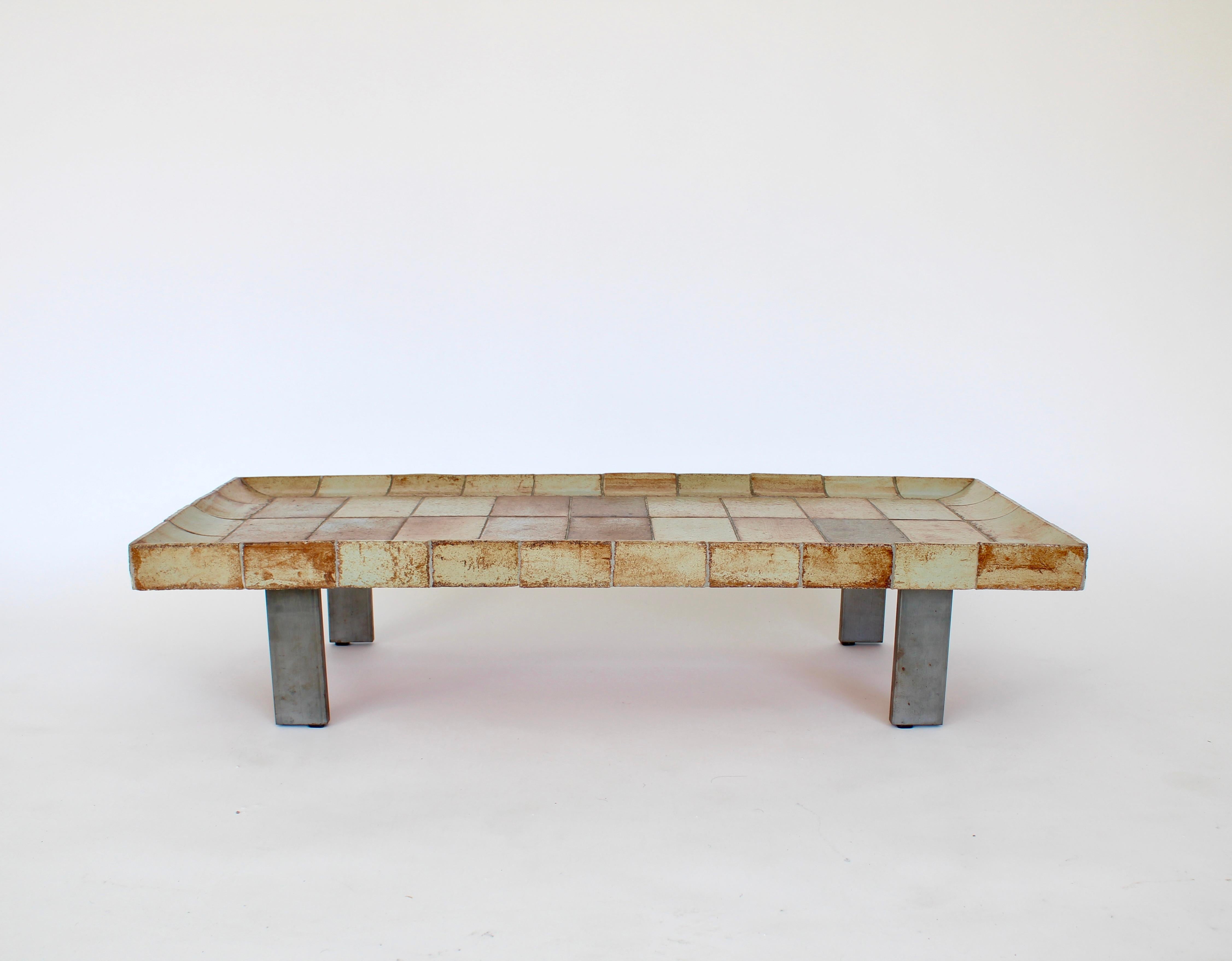 Roger Capron Table basse en céramique française modèle Cuvette. 
Cette table est composée de carreaux qui présentent chacun la forte influence du feu dans le four et varient dans des couleurs de bruns clairs chauds et de tan. 
Les carreaux