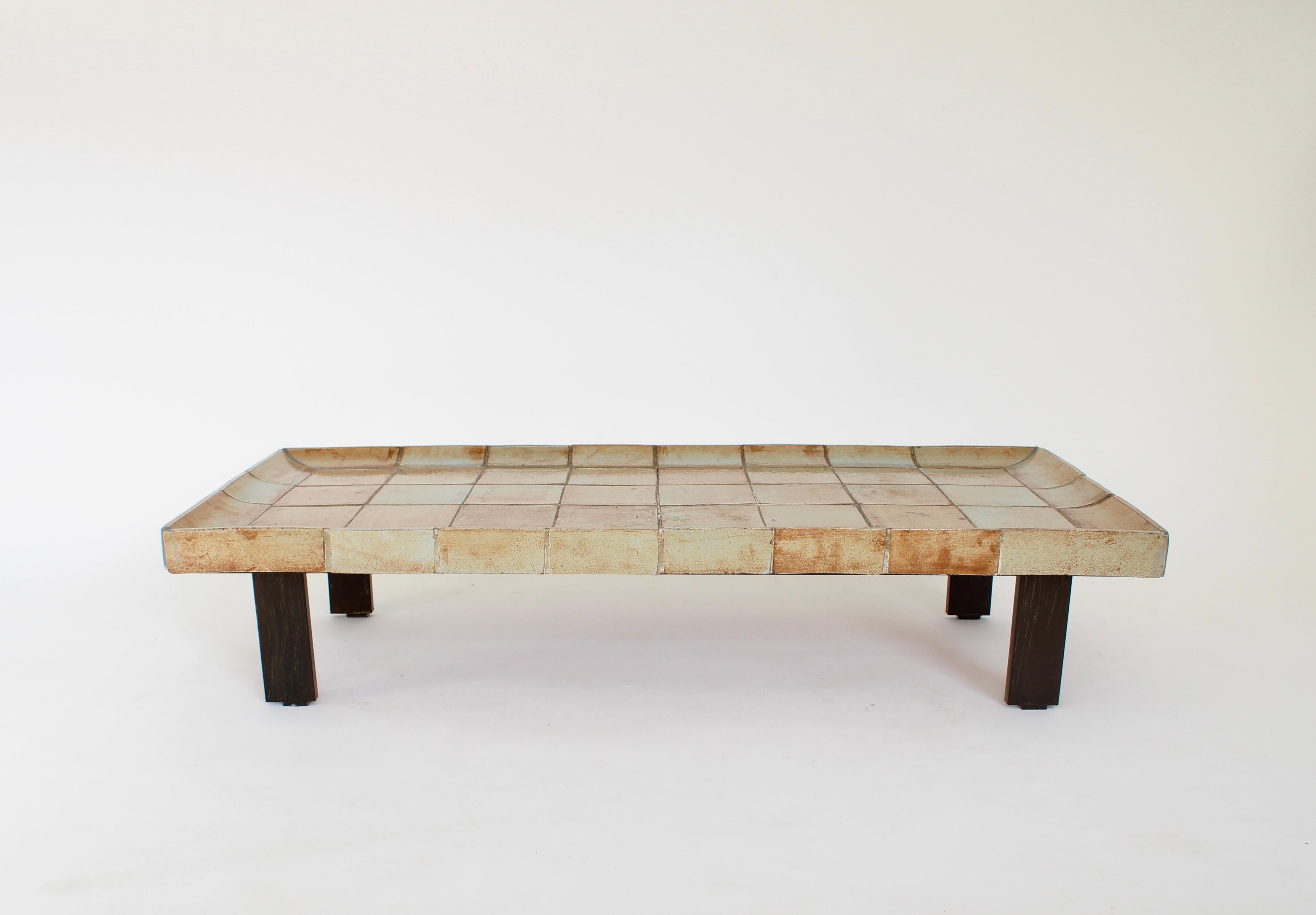 Roger Capron Table basse en céramique française modèle Cuvette. 
Cette table est composée de carreaux qui présentent chacun la forte influence du feu dans le four et dont les couleurs varient entre le presque blanc et les bruns clairs et chauds.