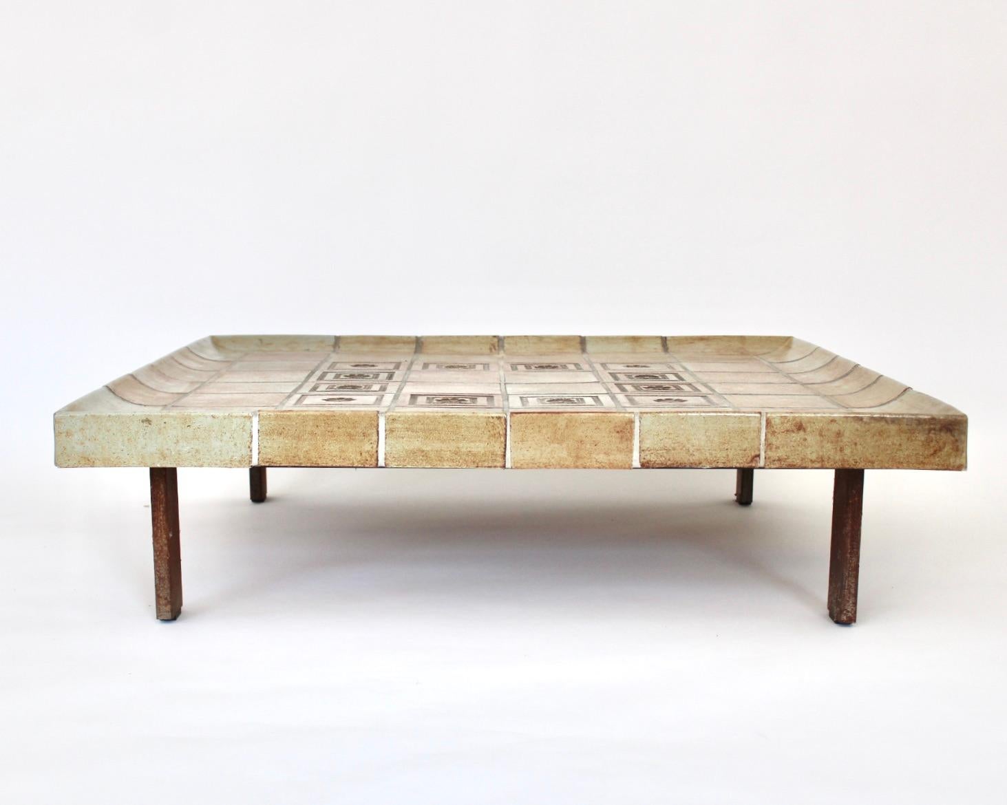 Roger Capron French ceramic tile coffee table model double size Cuvette. 
This table is composed of tiles that each exhibit the strong influence of the fire in the kiln and vary in colors of warm light browns and tan. The center tiles have
