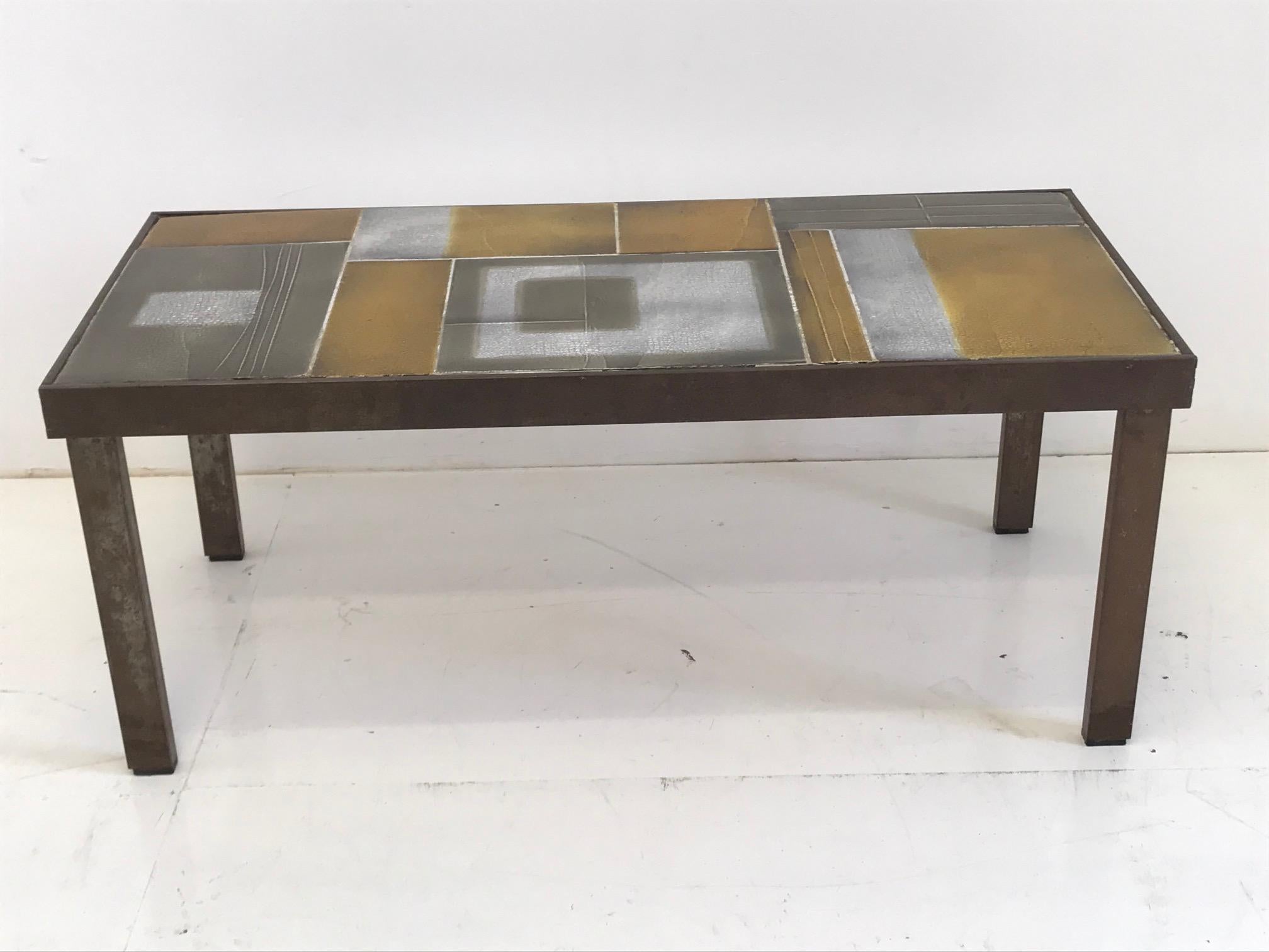 Coffee table, tabletop with geometric decoration of lava tiles glazed in shiny shades of brown, amber, white and warm grey, with various glaze effects, on metal frame and legs. Mid-20th century model designed and signed by the French artist Roger