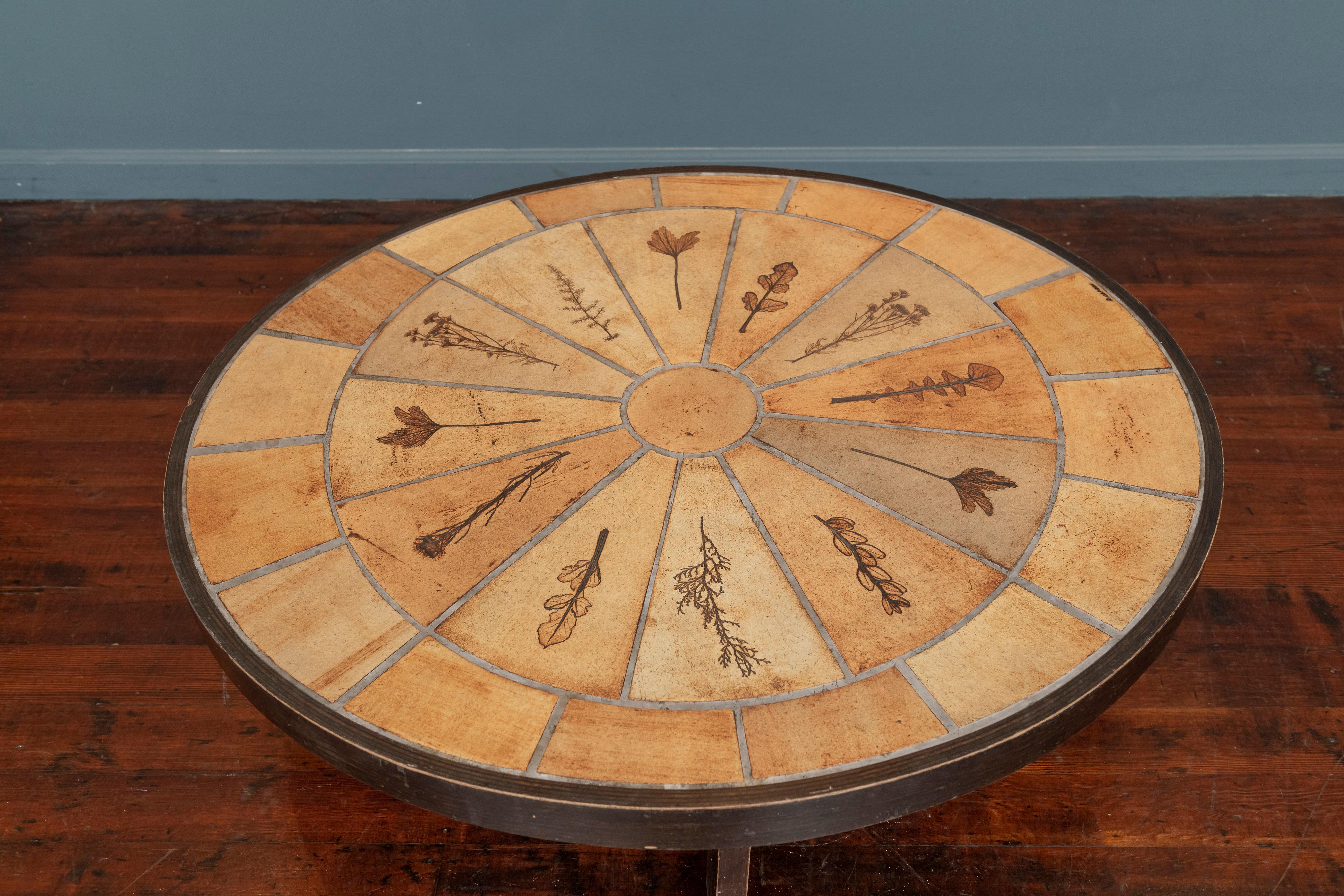 Roger Capron design ceramic oval Gres des Garrigues coffee table, France. Organic nature motif with impressed herbs and flowers into a decorative oval top on a stained banded top on opposing legs, signed.