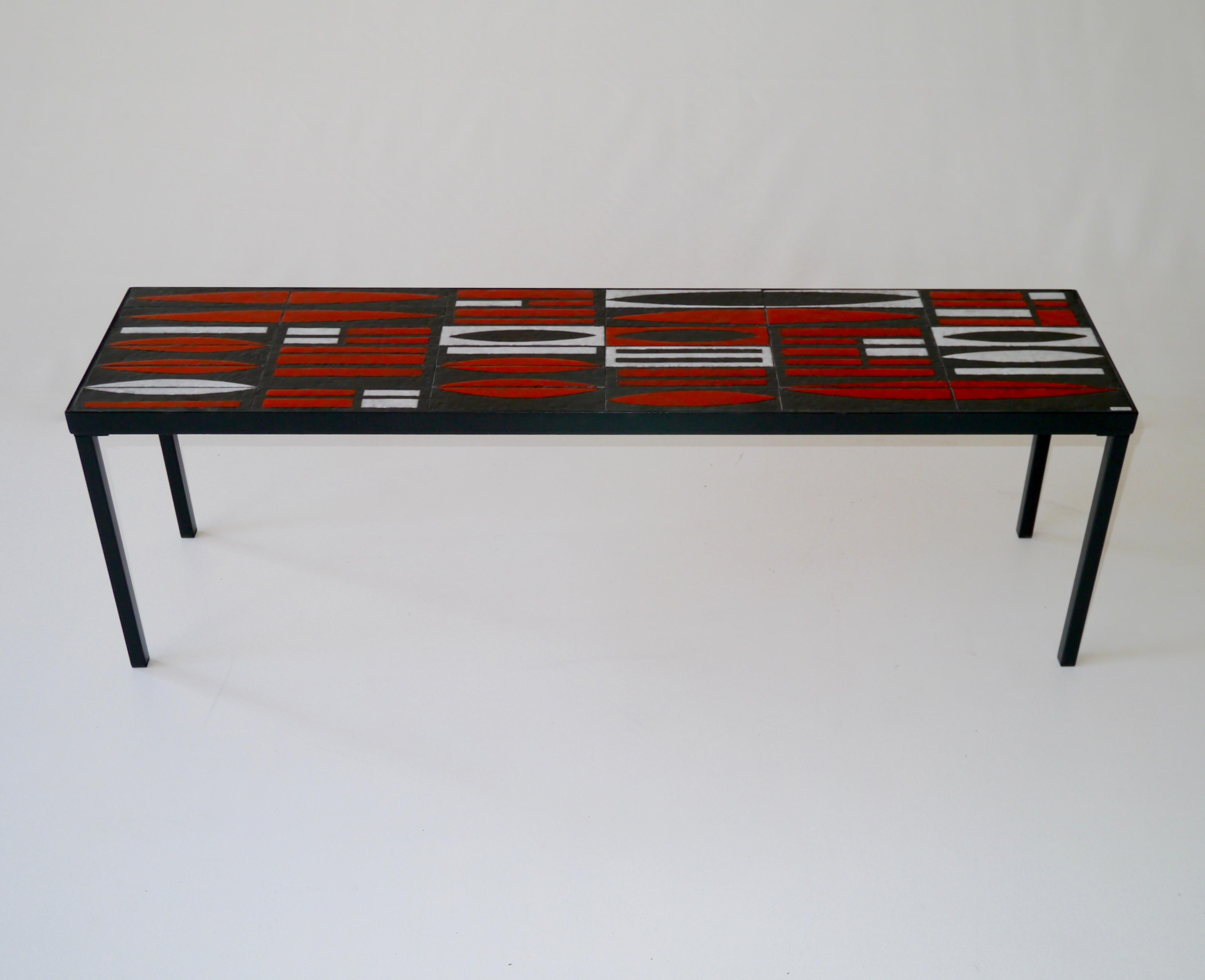 A wonderful and very unusual example of Roger Capron's work from the 1950s.
Black hammered ceramic tiles with rhythmic drawings realised in matte-white and shiny red glazes.
Signed by the Artist.
Frame and legs in black lacquered steel have been