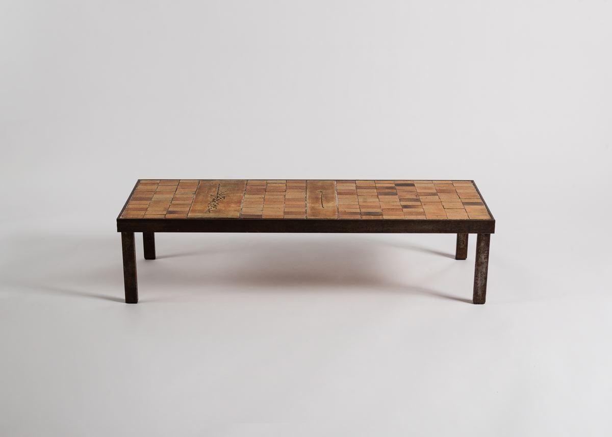 A coffee table with a simple, elegant, iron base, and a top of rectangular
tiles punctuated by beautifully inscribed images of grasses.

Inscribed: R. Capron.