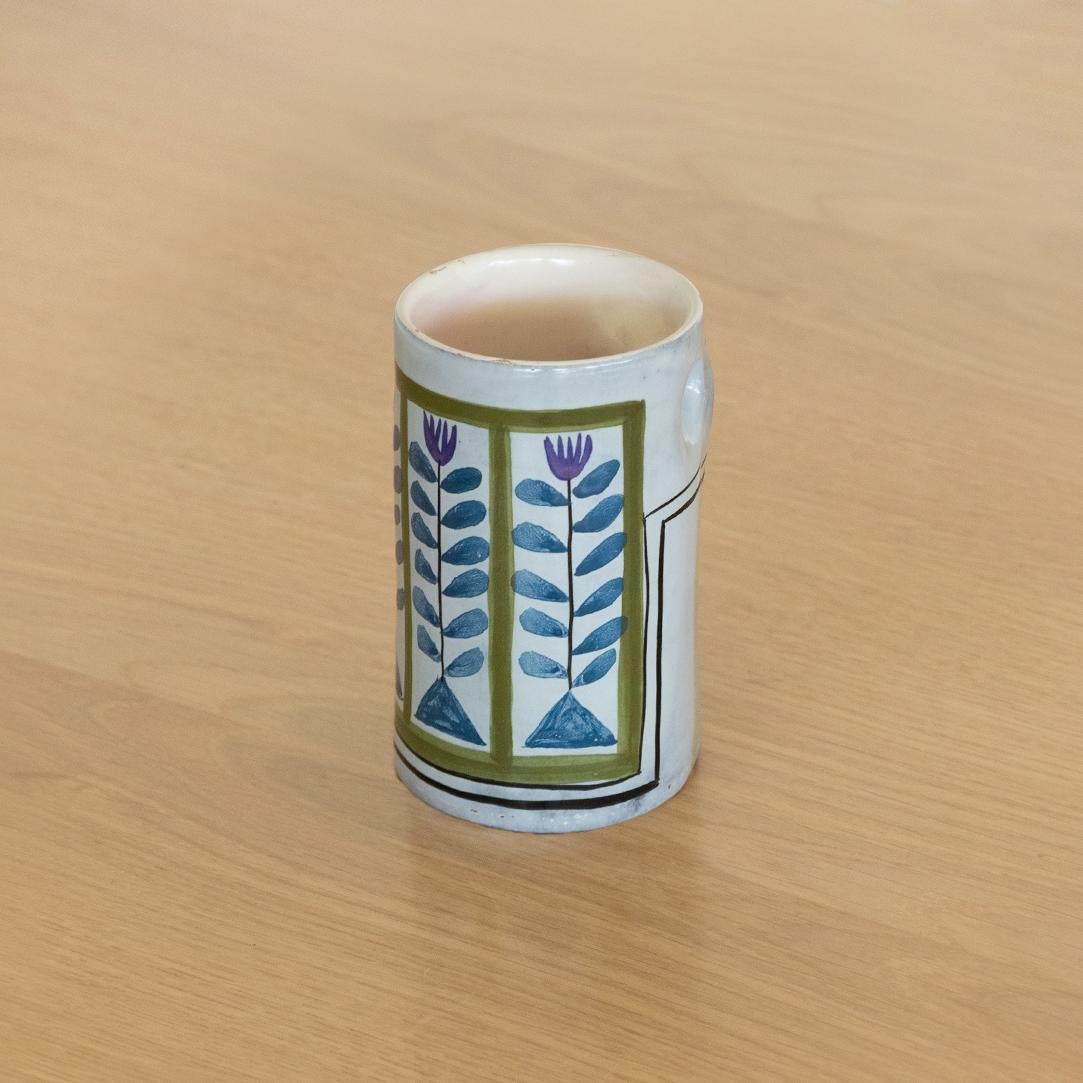 Lovely ceramic hand painted cup with blue, green and white flower motif by Roger Capron from France, 1960's. Great desk accessory to hold pens. Signed on underside.