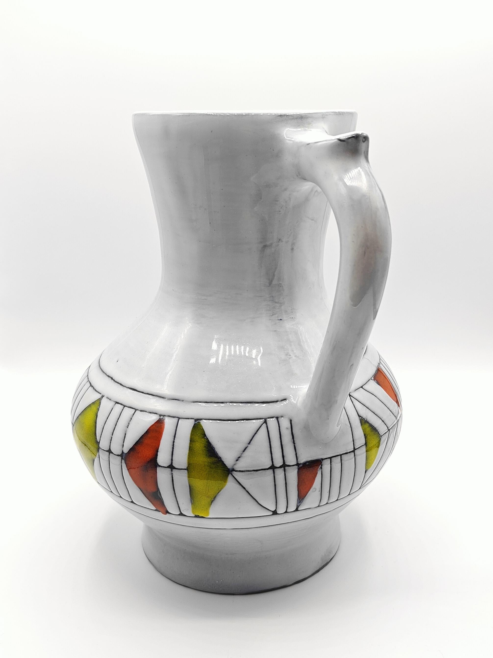 Pitcher by Roger Capron, ceramist in Vallauris, France, circa 1962. This pitcher is made of enamelled terracotta, signed and numbered under the base. 

This geometric abstract decoration, with yellow and red on white enamel, gives a design touch