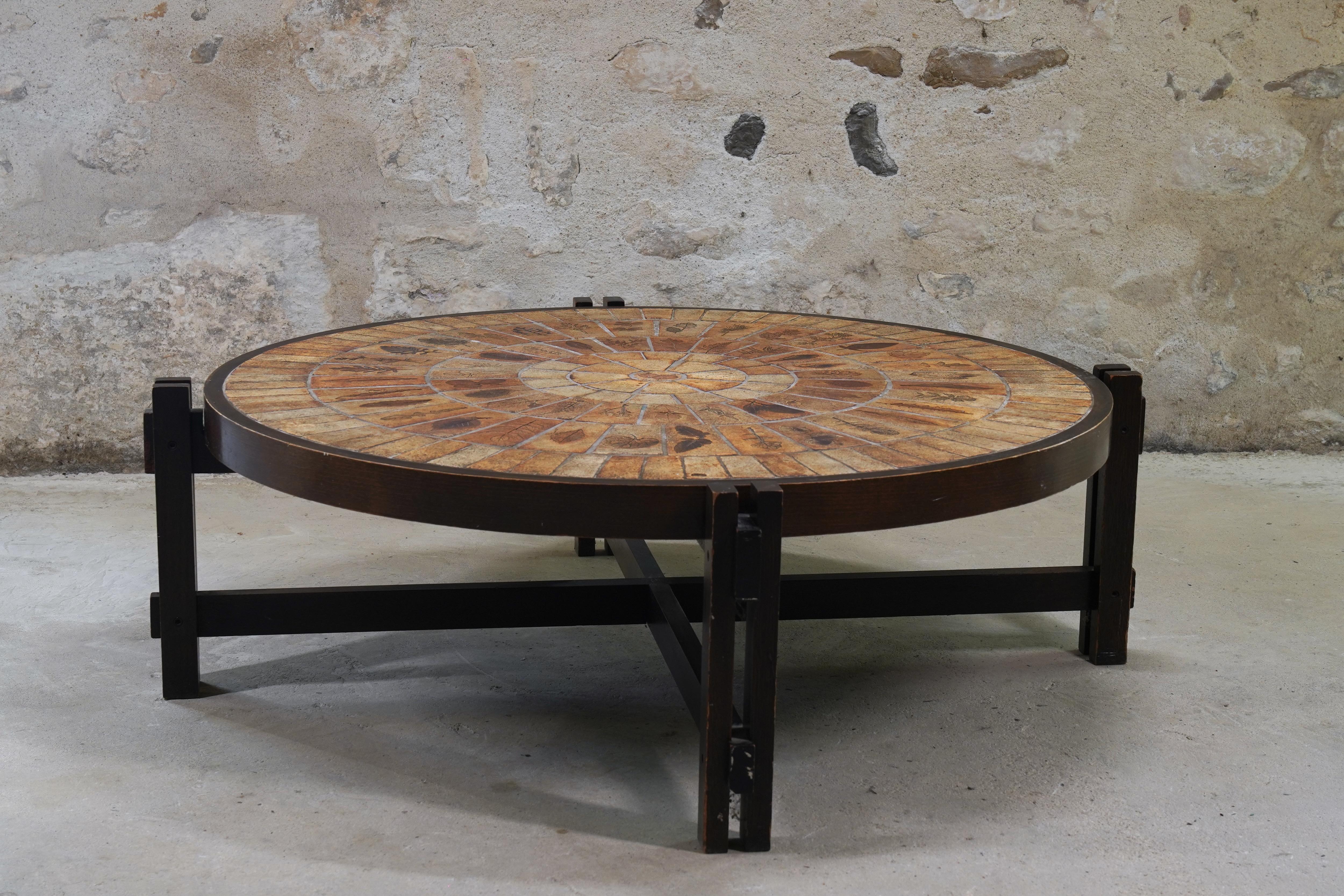 Lovely Roger Capron ceramic coffee table with Garrigue tiles from France, circa 1960s.

The handcrafted Garrigue tiles were produced by a technique in which real leaves were pressed into the clay and, during firing, disintegrated, leaving a finely