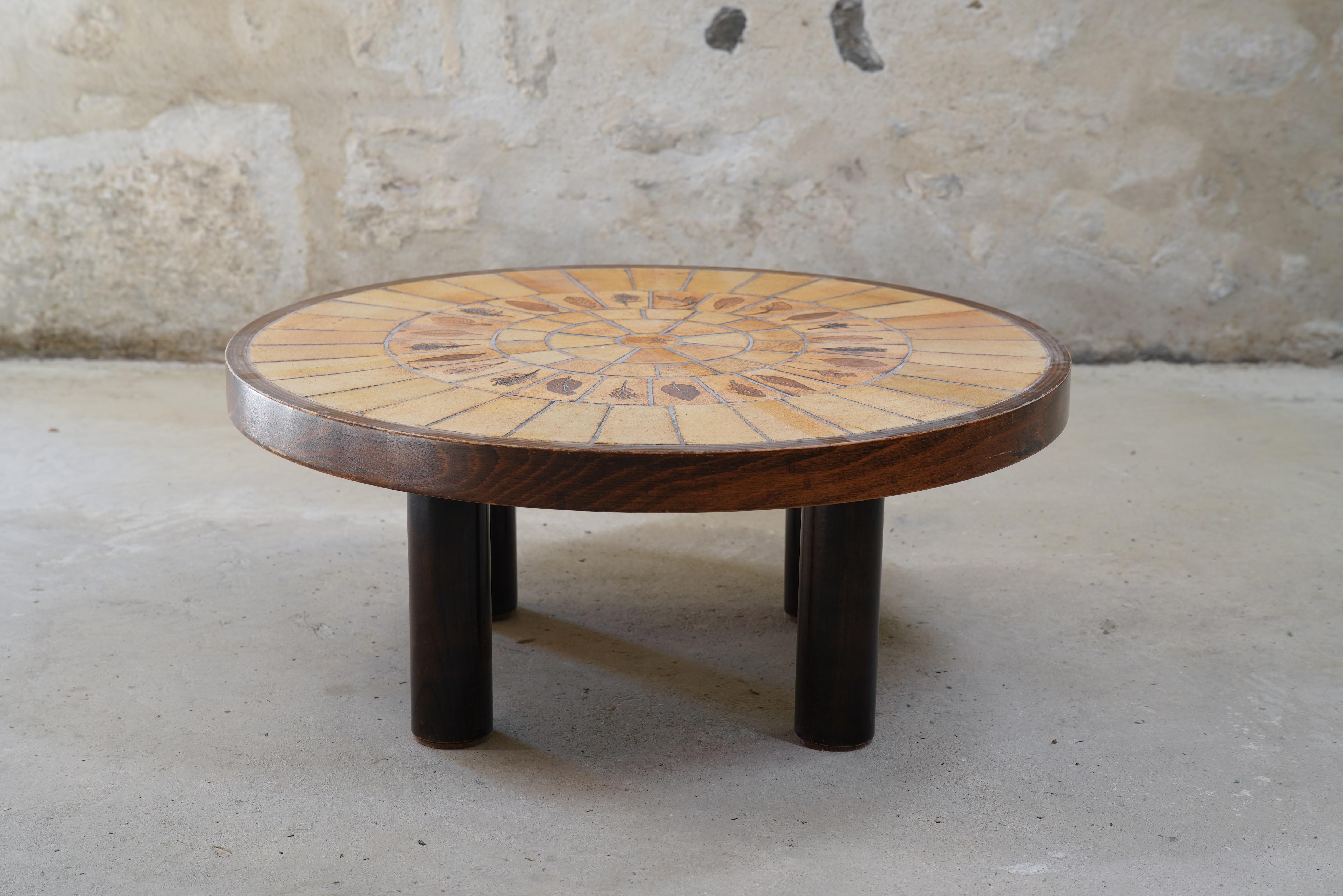 Impressionnante table basse en céramique Roger Capron avec des carreaux de Garrigue de France, vers les années 1960.

Les carreaux de Garrigue, fabriqués à la main, sont issus d'une technique où de vraies feuilles sont pressées dans l'argile et se