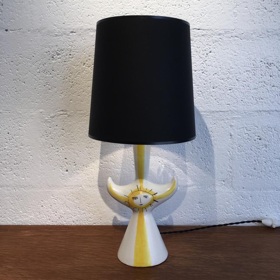 Lamp base in faience, conical base bristling with horns, presenting a sun, black and yellow enamels on a white background,
Enamelled handwritten signature 