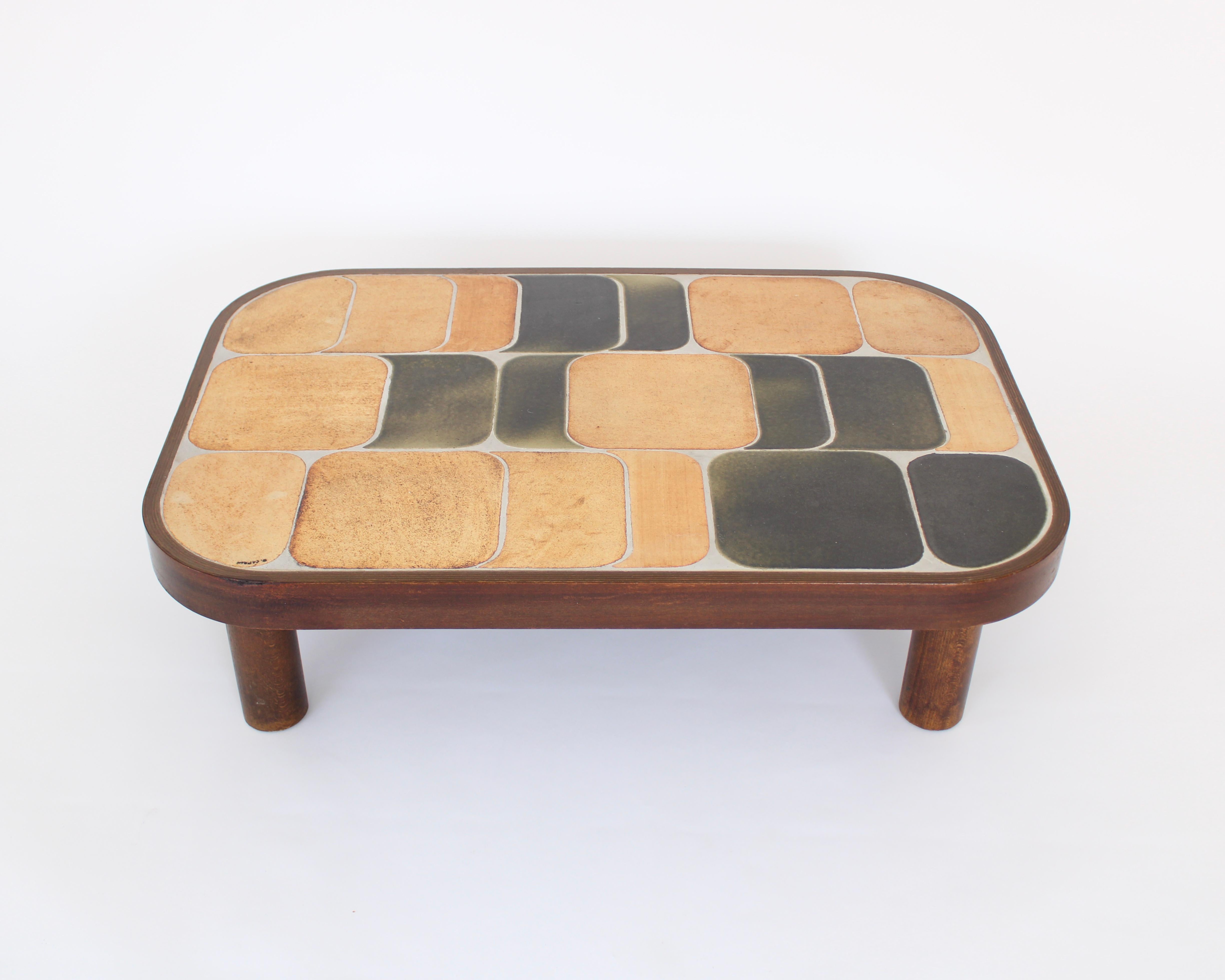 Roger Capron Sho-Gun or Shogun model coffee table with ceramic tile top with beige brown enameled tiles on mahogany base and feet. Signed R Capron.
The colors vary from table to table as a result of the temperature of the firing in the kiln. No