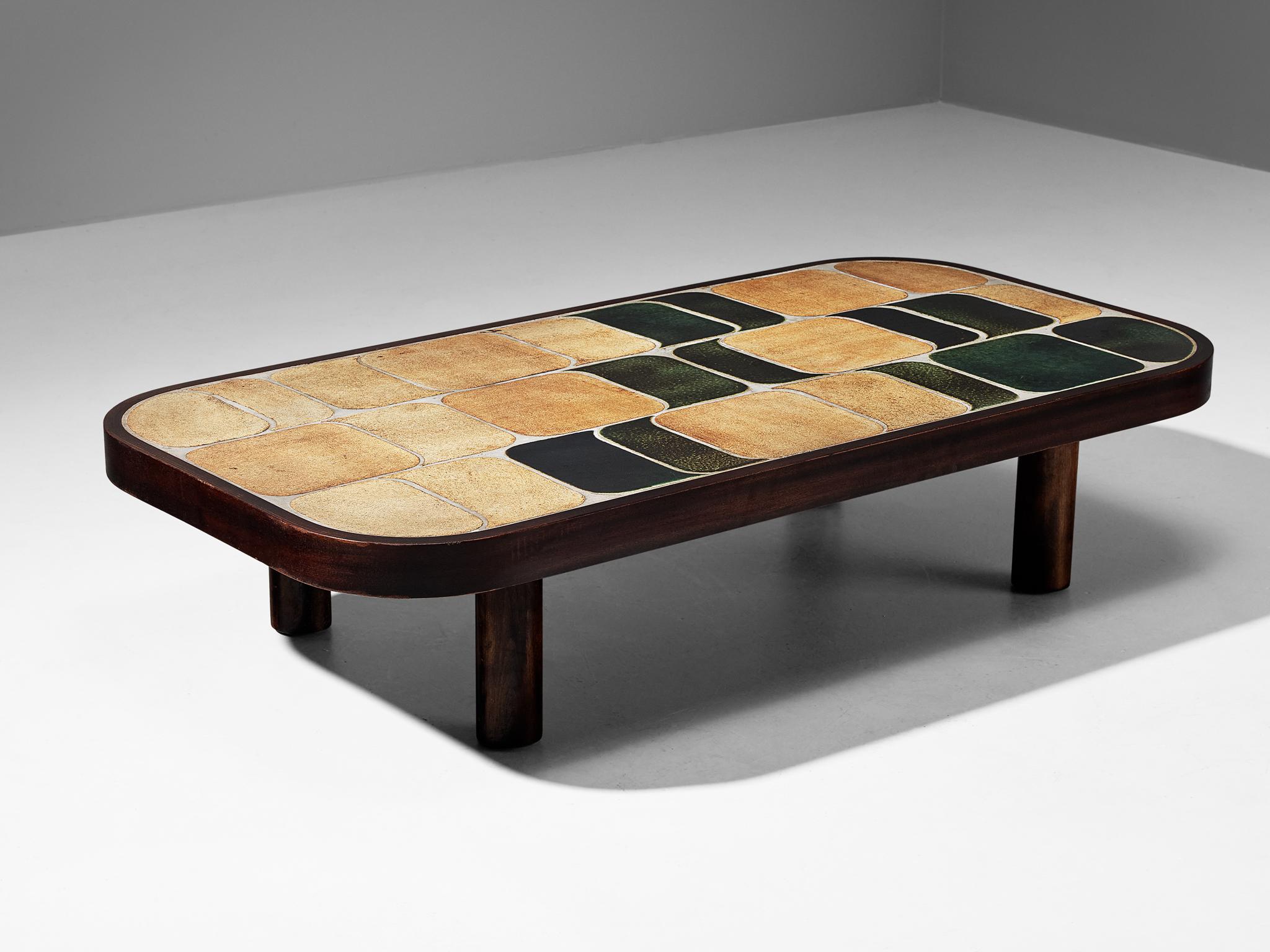 Roger Capron, coffee table, ceramic, stained mahogany, stained beech, France, 1960s.

French coffee table with wonderful composed ceramic tiles by French designer Roger Capron. Both the tiles as well as the frame feature rounded corners. The tiles