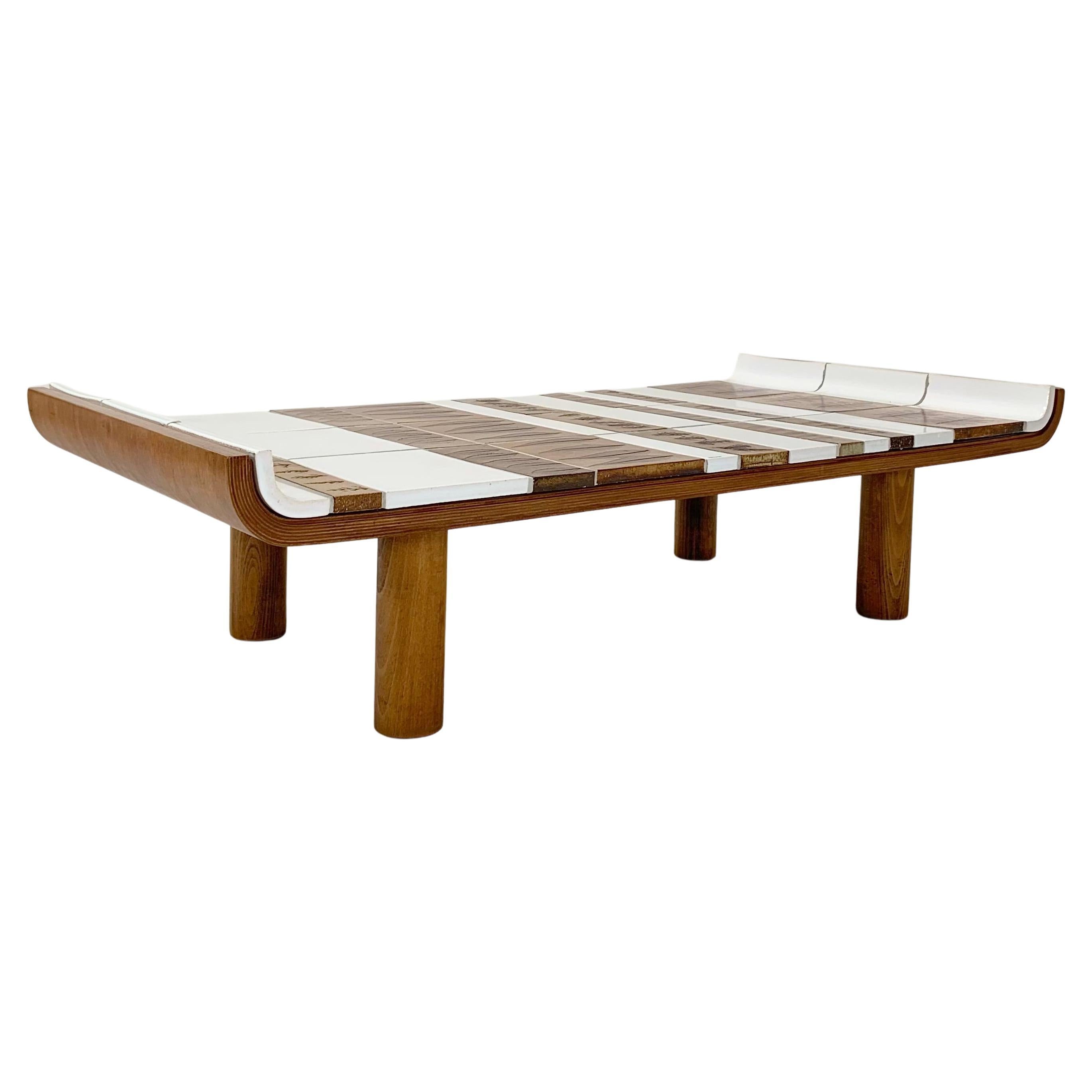 Bellissimo tavolino Roger Capron Tk1, arredamento Moribana, circa 1974, Francia.
4 piedi cilindrici in legno di quercia compensato e smaltato  piastrelle in ceramica bianca e marrone, decorazioni con foglie ed erbe. Firmato Roger Capron.
Questo