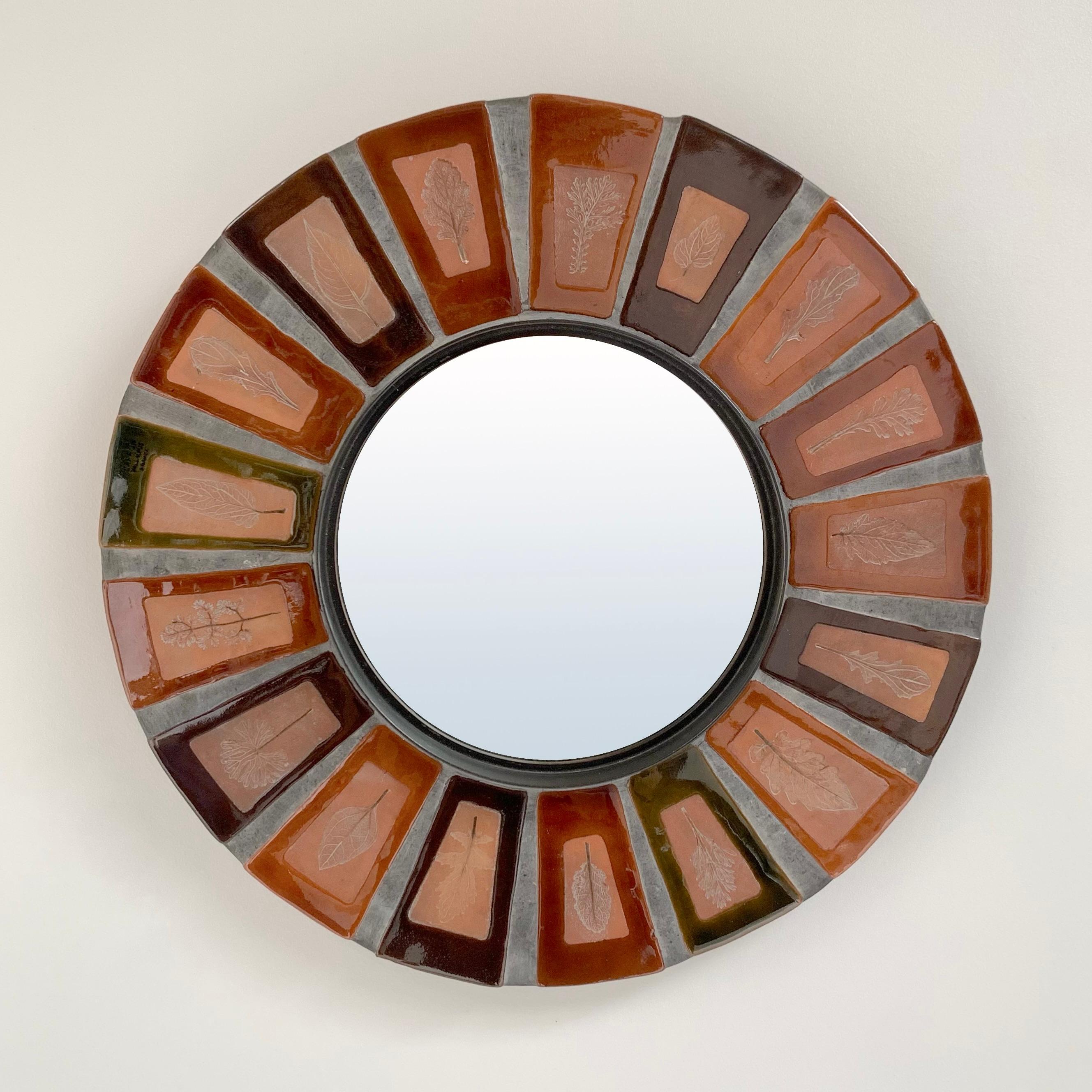Roger Capron round wall mirror, circa 1970, France.
Herbier model, sandstone enameled tiles, metal, mirror.
Stamped Capron Vallauris France. 
Very decorative mirror by Capron rare on the market.
Dimensions: 40 cm: total diameter, 20cm : diameter of