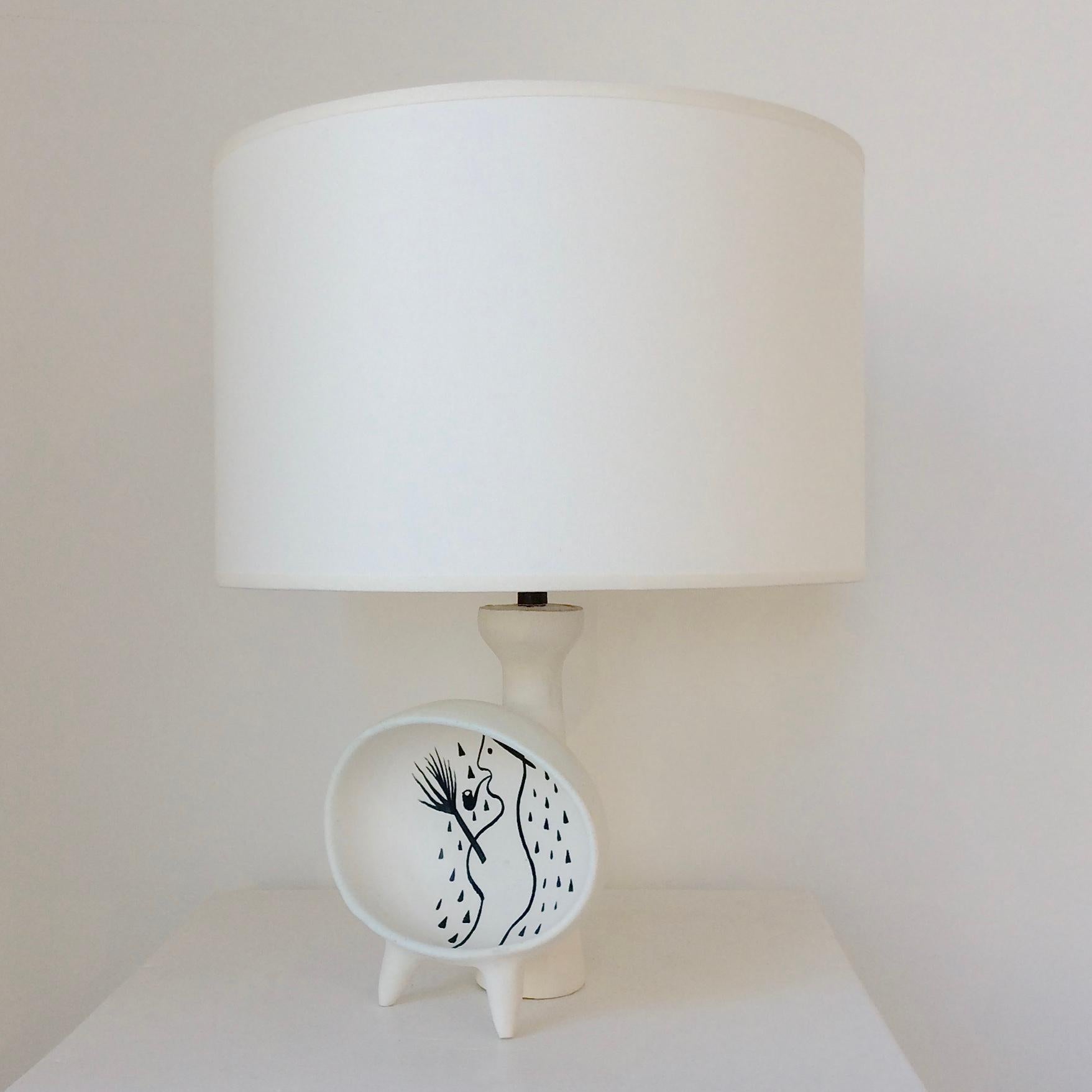 Rare Roger Capron table lamp, circa 1955, France.
White enameled ceramic, black snowman decor ( drawing inspired by Jacques Prévert's poem: song for children in winter ).
Rewired, new fabric shade.
One E27 bulb of 40 w.
Dimensions: total height 35