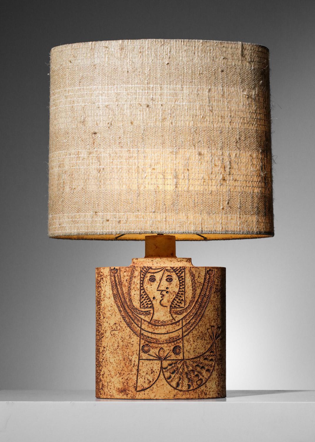 Beautiful table lamp from the 60's by Roger Capron made in collaboration with Jean Derval. Structure of the base of the lamp in chamotte clay, decoration imagined by Jean Derval representing a stylized mermaid woman. Original woven lampshade,