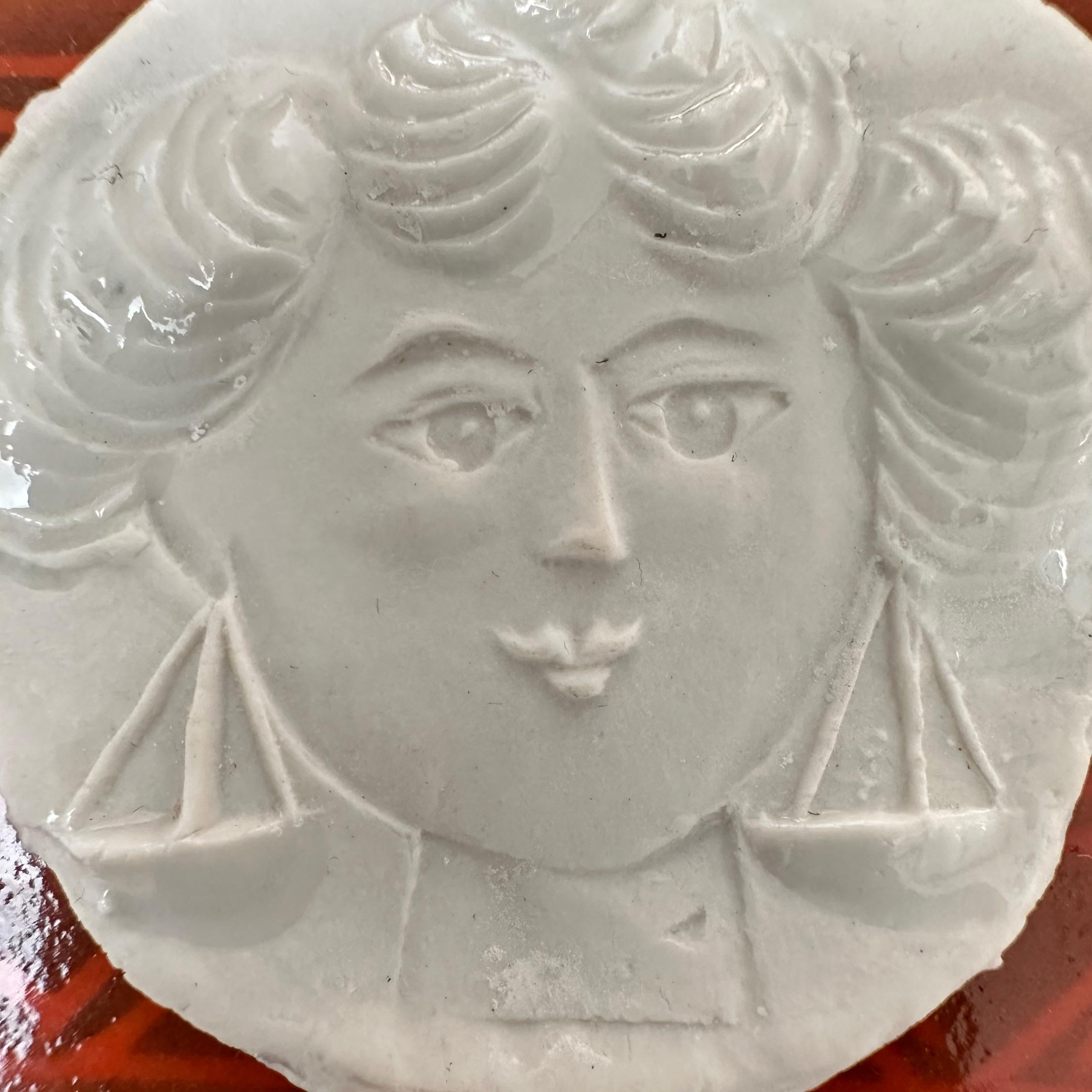 Thin sheet of partially glazed stamped porcelain with the motif of a female figure embodying the Libra sign.

Rare item from a limited series created by the artist in 1973 around the zodiac signs.

Although unsigned, this delicate artist's jewel is