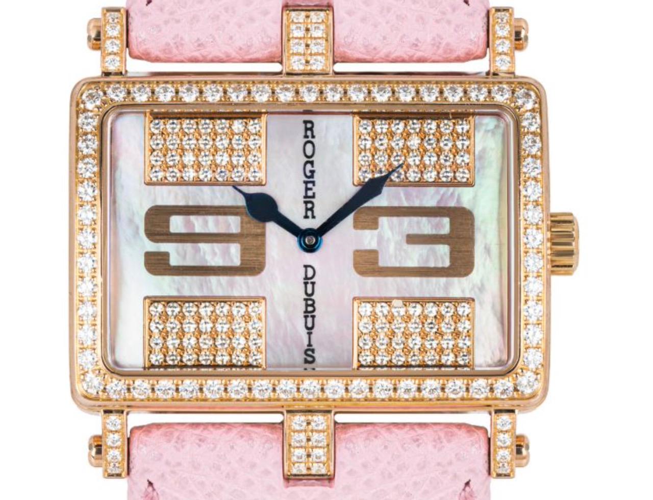 A dazzling Ladies 37mm Roger Dubuis Too Much wristwatch crafted in rose gold. Features a stunning mother of pearl dial with a pave set, arabic numbers 3,9 and blueed steel sword shape hands. Complimenting the dial is a rose gold bezel set with 60