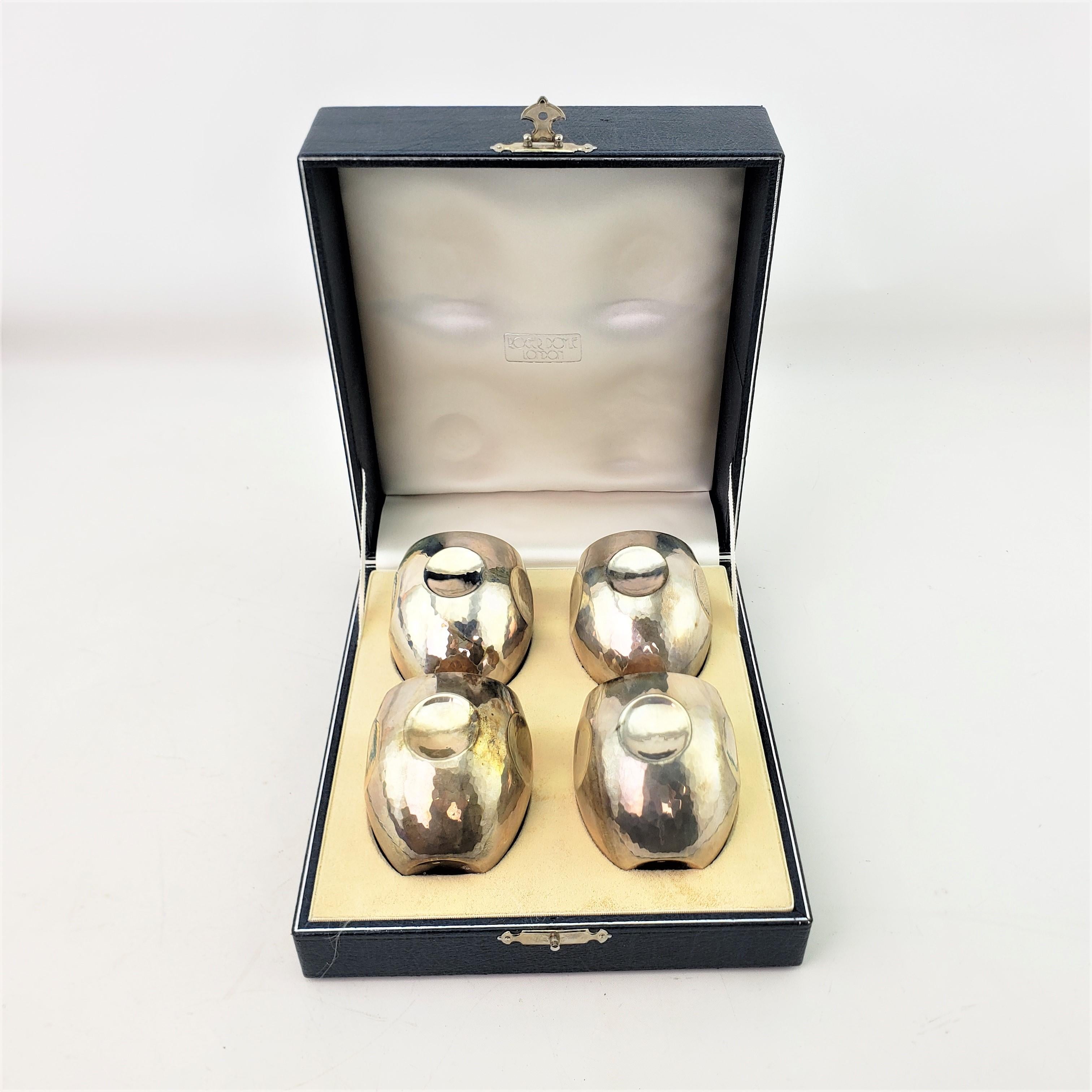 This set of four spirit cups were made by the well known Roger Doyle silversmith of England in 2000 in an early Elizabethan style. The cups are hand-crafted in a tulip shape with large dimples around the sides with a gilt washed interior and are