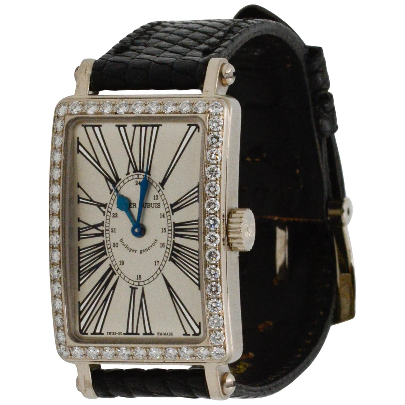 Model: Roger Dubuis Muchmore #203546
Case Materia: 18k White Gold 
Dial: Rectangular Silver Roman with Diamond Bezel 
Strap: Black with Tang Buckle 
Circa 2000, Papers only
