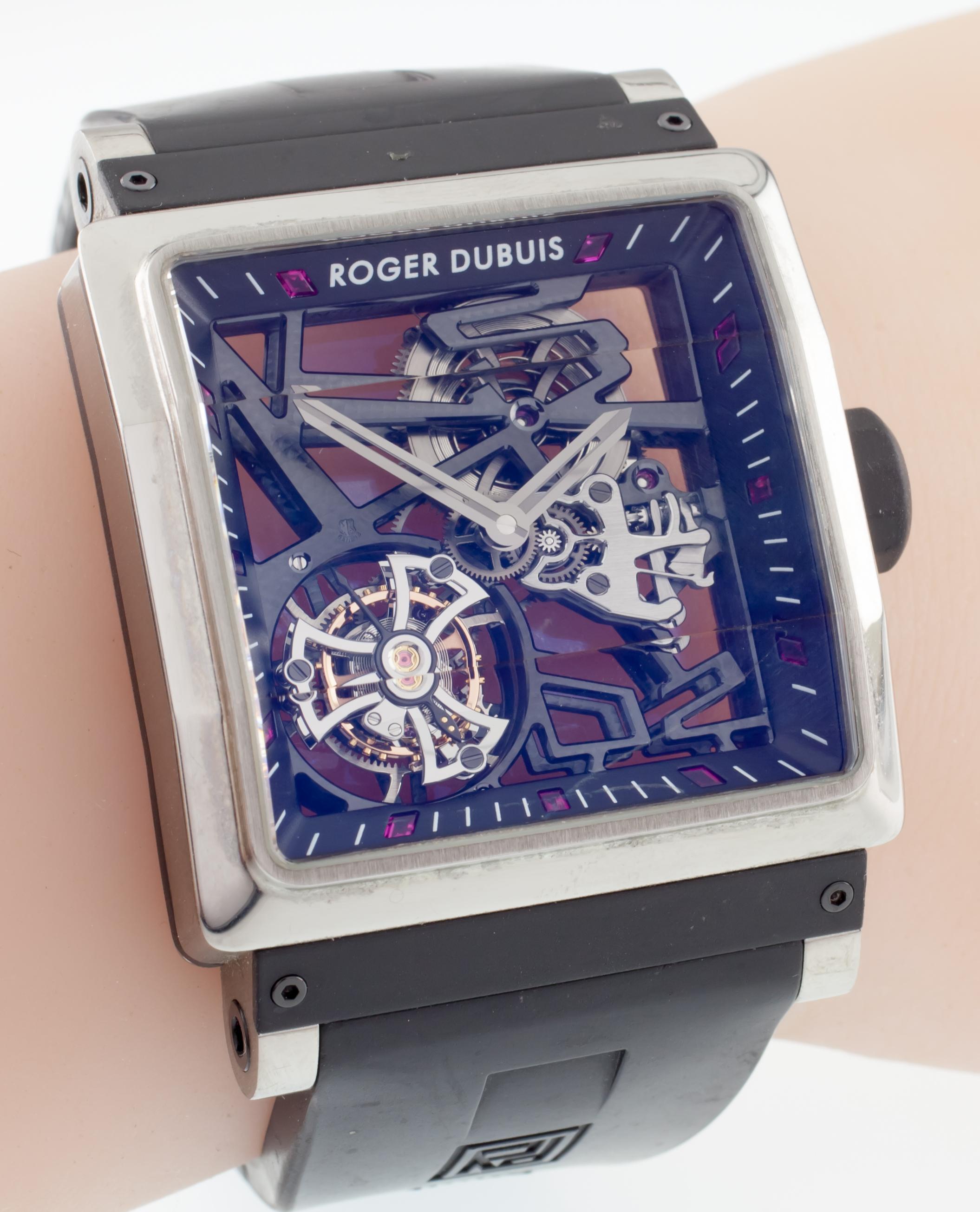 Model: King Square
Limited Edition #110 of 280
Titanium Case w/ Rubber Elements
40 mm Wide
Includes Tourbillon Movement
Beveled Crystal over Skeleton Dial
Ruby Accents on Inner Bezel
Black Rubber Strap w/ Original Robert Dubuis Clasp
Piece is in