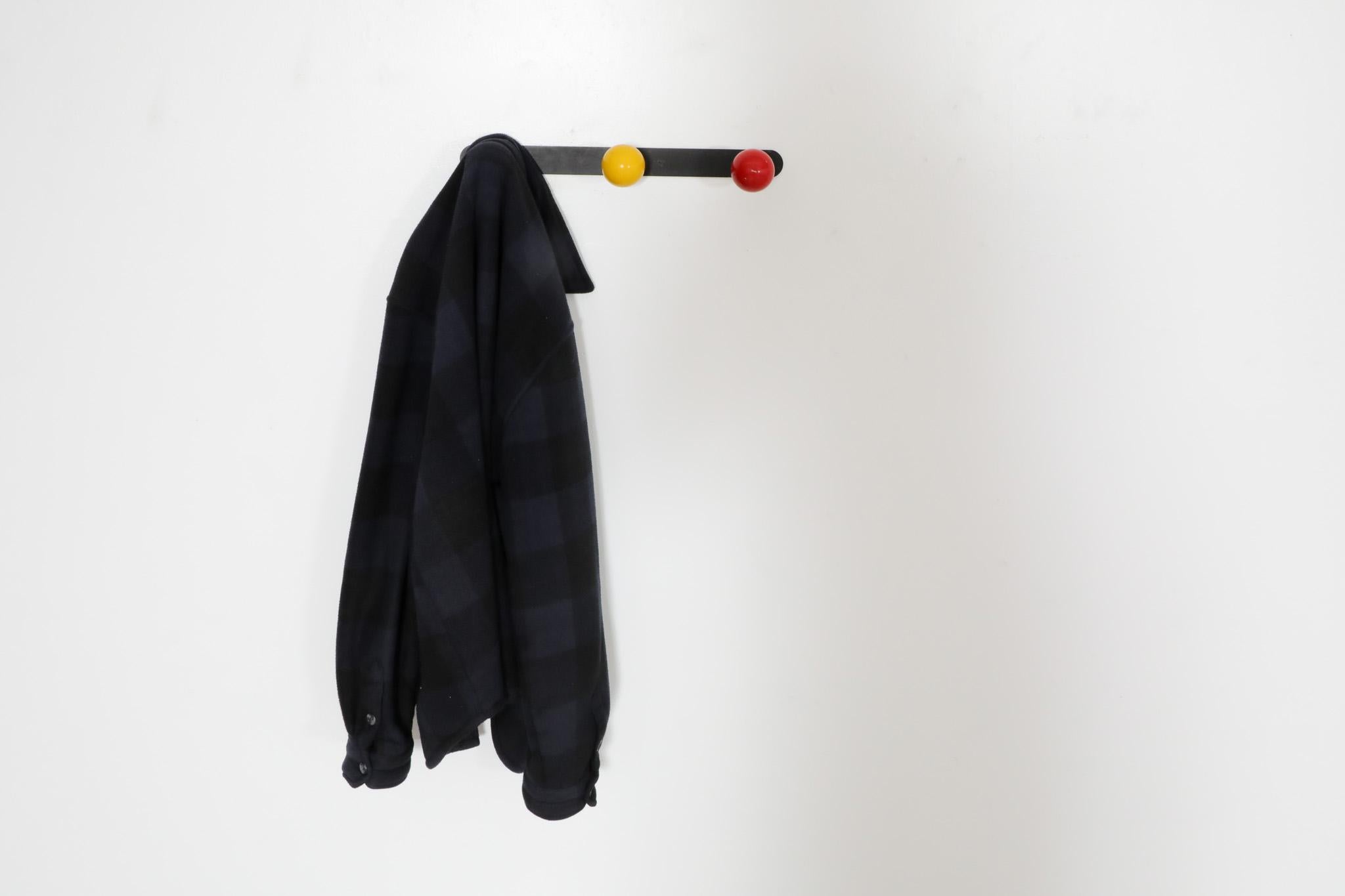 Porte-manteau mural français Roger Feraud (attr.) du milieu du siècle dernier, années 1950. Base en métal émaillé noir avec crochets en bois multicolores. Parfait pour ajouter de la couleur et de l'éclat à une entrée ou à un placard.  En état
