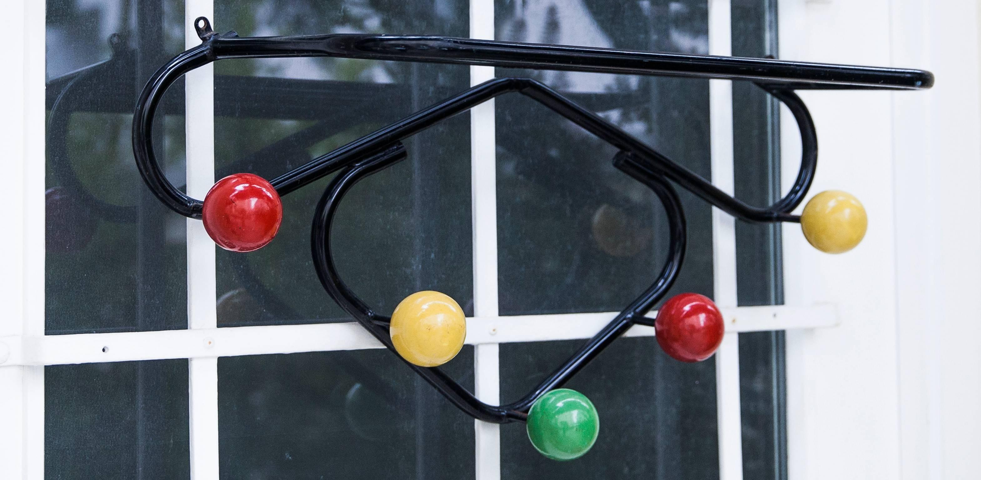 Vintage original French midcentury wall coat rack designed in the 1950s by Roger Feraud. Lacquered metal structure with five colored wooden balls. Uncommon model. Very architectural piece.