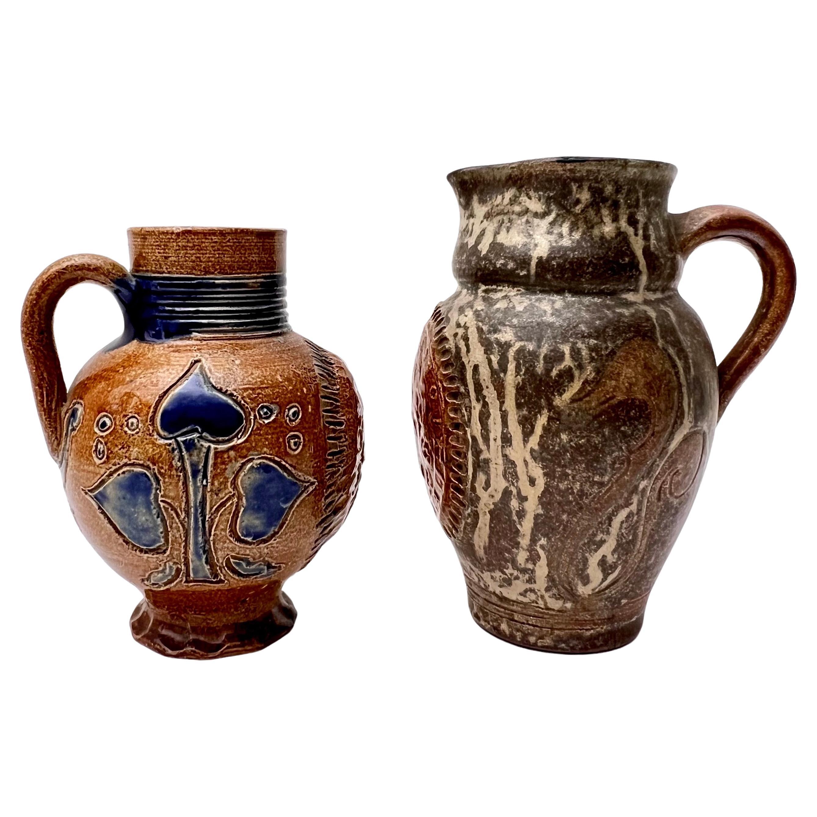 Great near pair of Roger Guerin pitcher and vase.  One is a pitcher and one is a handled vase. Each is stylized with a Belgium Crest or Coat of Arms in the front of the pitcher with decorative motifs along the sides.  Great for any collector of