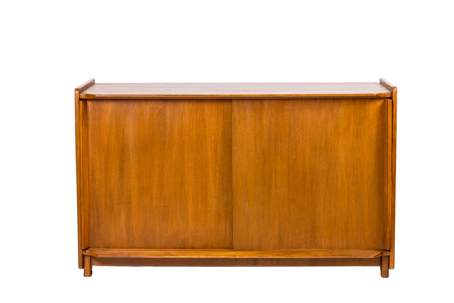 Roger Landault, attributed to. 

Sideboard in oak opening on the front with two sliding doors. A shelf inside. Rectangular and bevelled handles.

French work realized in the 1950s.

Dimensions : H 76 x W 125 x D 45 cm.
