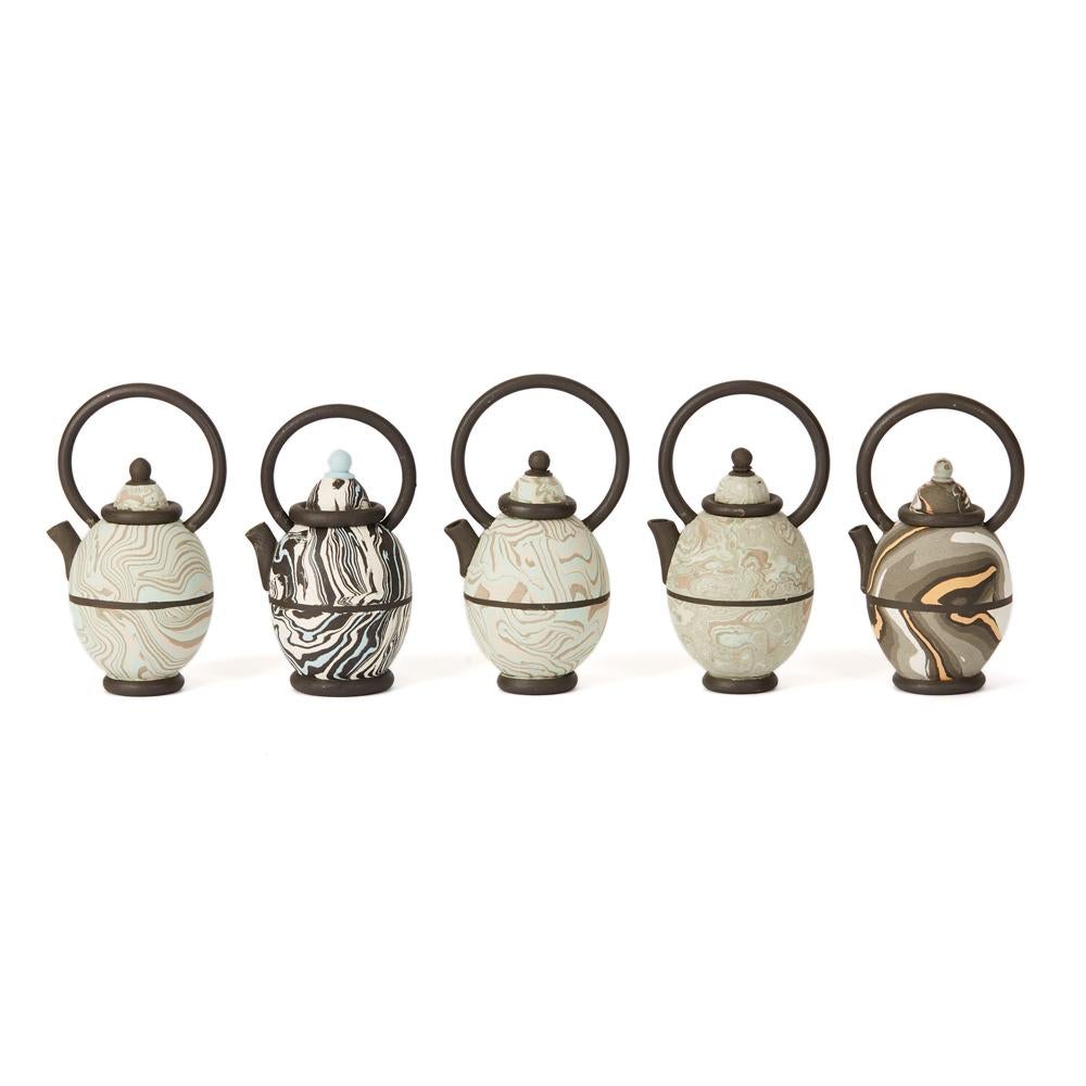 A rare collection thirteen stylish vintage miniature studio pottery marbled clay teapots of egg shape with tall loop kettle style handles. The teapots are are press moulded with marbled clay, this is coloured clay pressed and rolled together to give