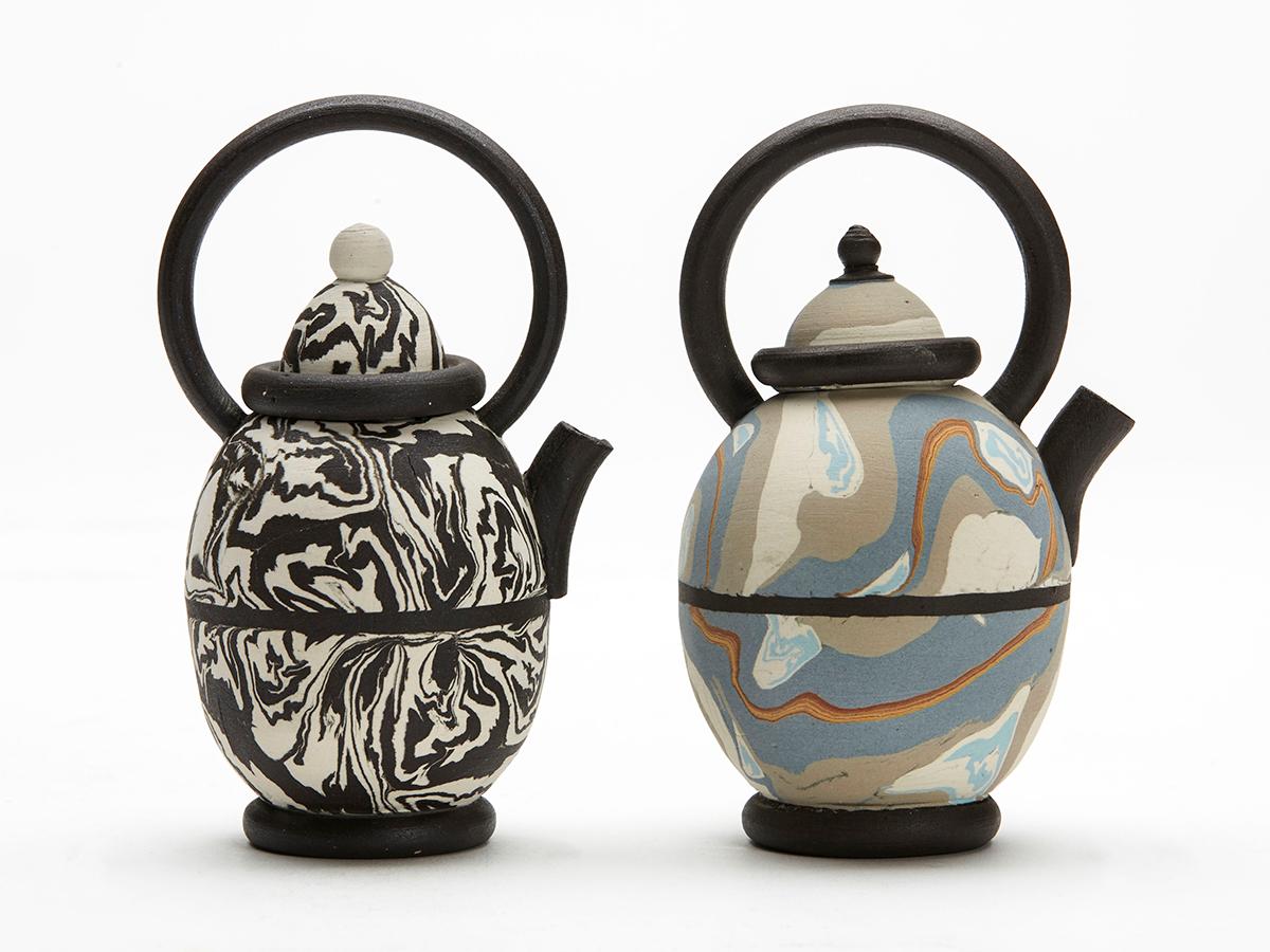 A stylish pair vintage miniature Studio Pottery marbled clay teapots of egg shape with tall loop kettle style handles by Robert Michell and dated 1984. The teapots are press molded with marbled clay, this is colored clay pressed and rolled together