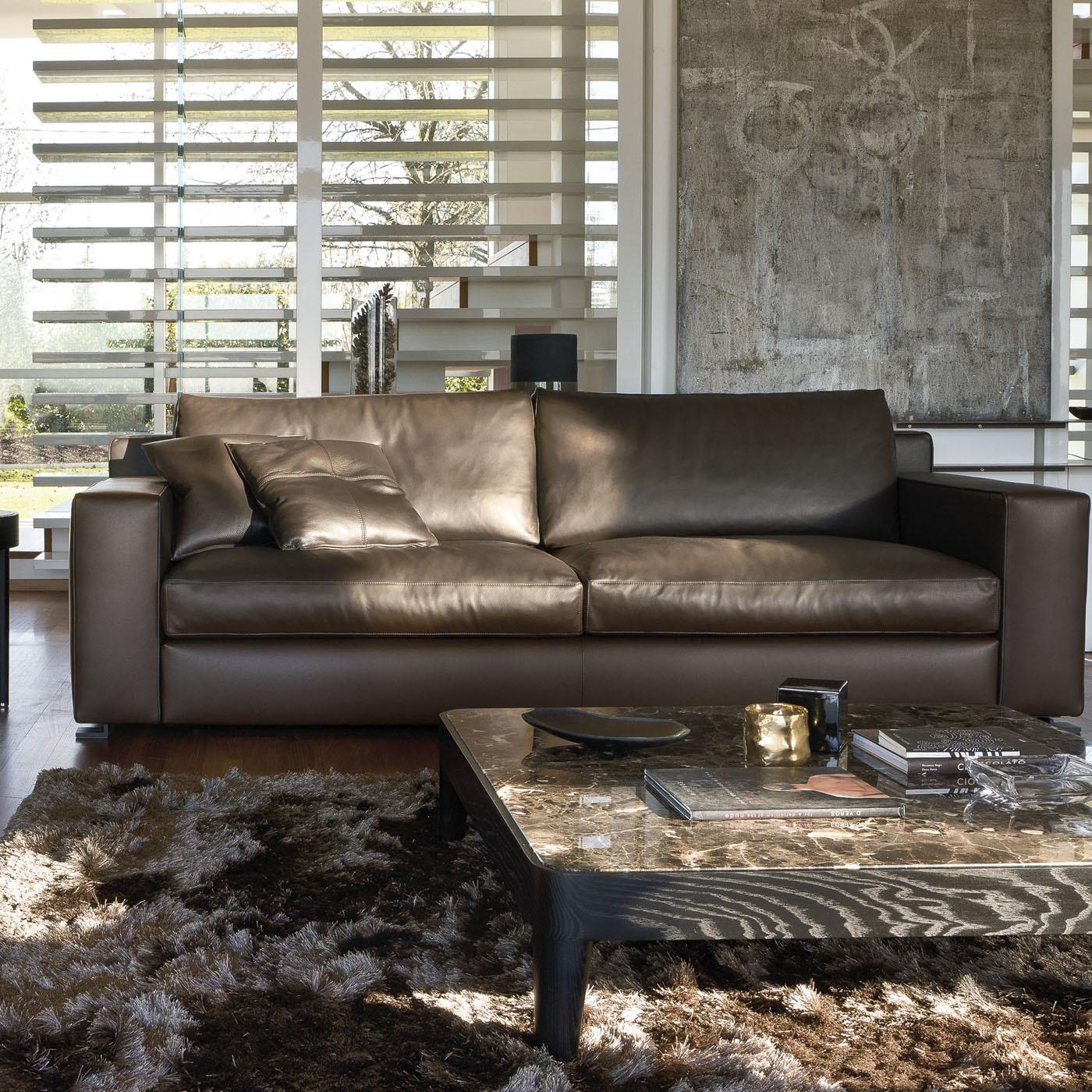 Upholstered in soft mocha-colored leather (col. Cristal 25 cat. Anilina) with matching stitching that adds a luxury feel to its minimalist design, this sofa will be eye-catching in any decor. Its solid and linear design is raised on black square