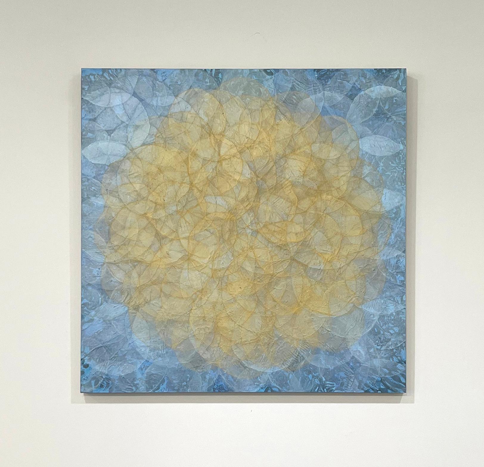 This abstract painting by Roger Mudre is made with acrylic paint over mica powder and cradled birch panel. Lightly translucent concentric circles overlap throughout the composition, creating a glowing effect of a yellow-gold circle at the center,