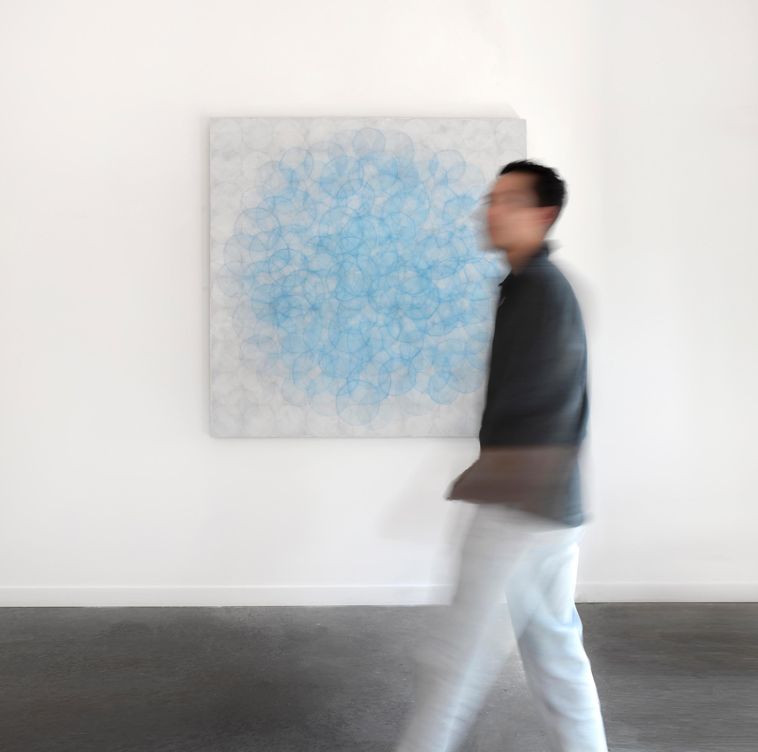 Dieses große abstrakte zeitgenössische Gemälde von Roger Mudre zeigt viele leichte Kreisformen, die konzentrisch übereinander geschichtet sind, und eine kühle blaue und silberne Farbpalette. Das Werk ist mit Acrylfarbe über Marmorstaub und