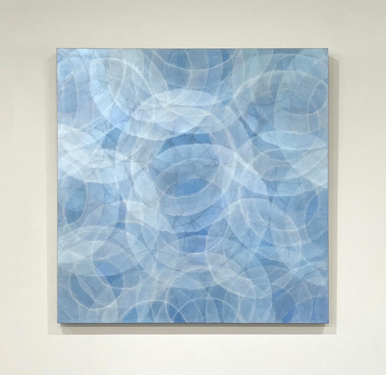 This abstract painting by Roger Mudre is made with acrylic paint over mica powder on cradled birch panel. It features a light blue and silver palette, with the light outlines of circles which almost appear to glow overlapping one another throughout