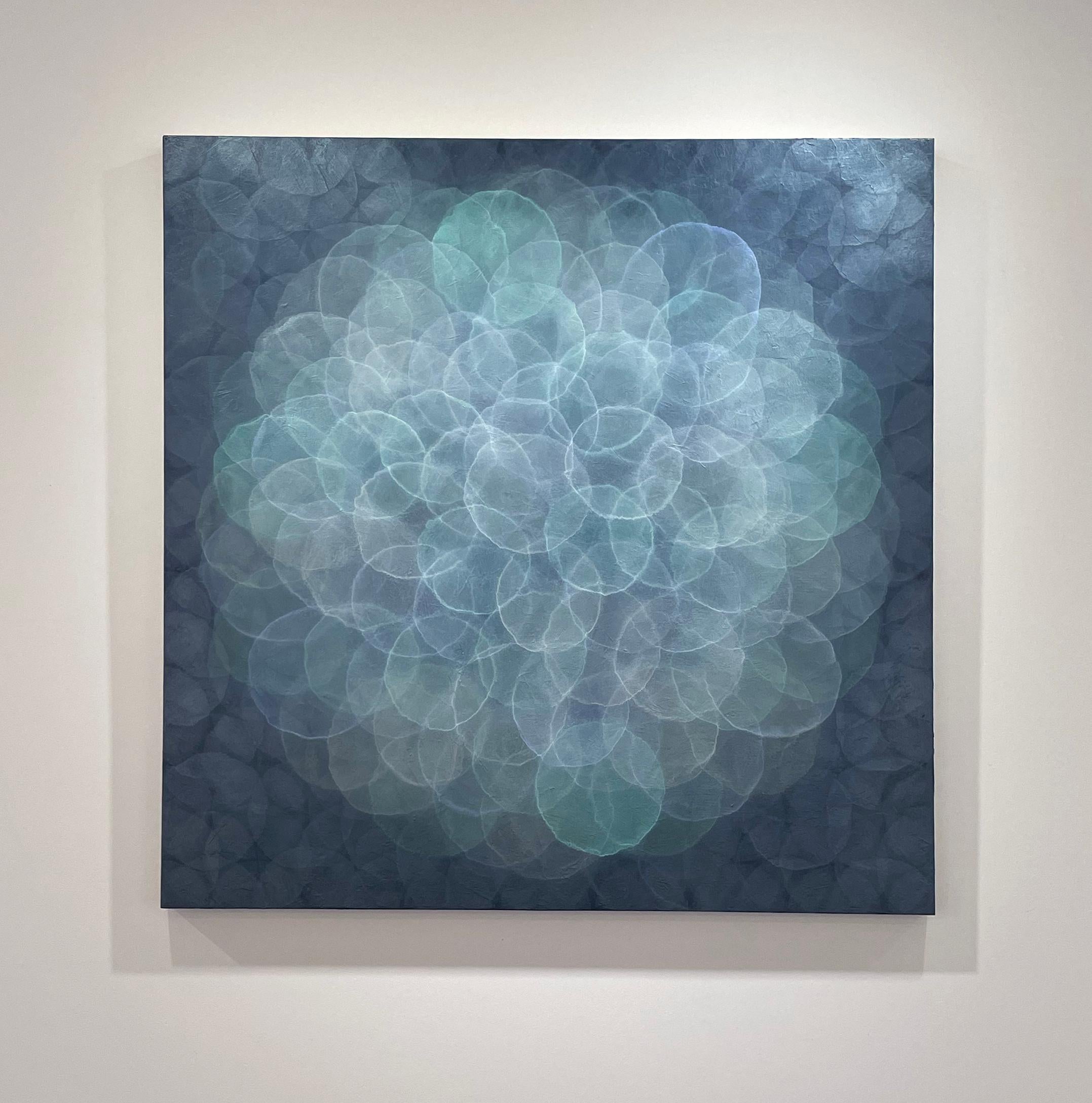 This abstract painting by Roger Mudre has a cool blue, green, and silver palette. Made with acrylic paint over marble dust and mica powder on cradled birch panel, it features small, overlapping circles that almost appear to glow, assembled in a