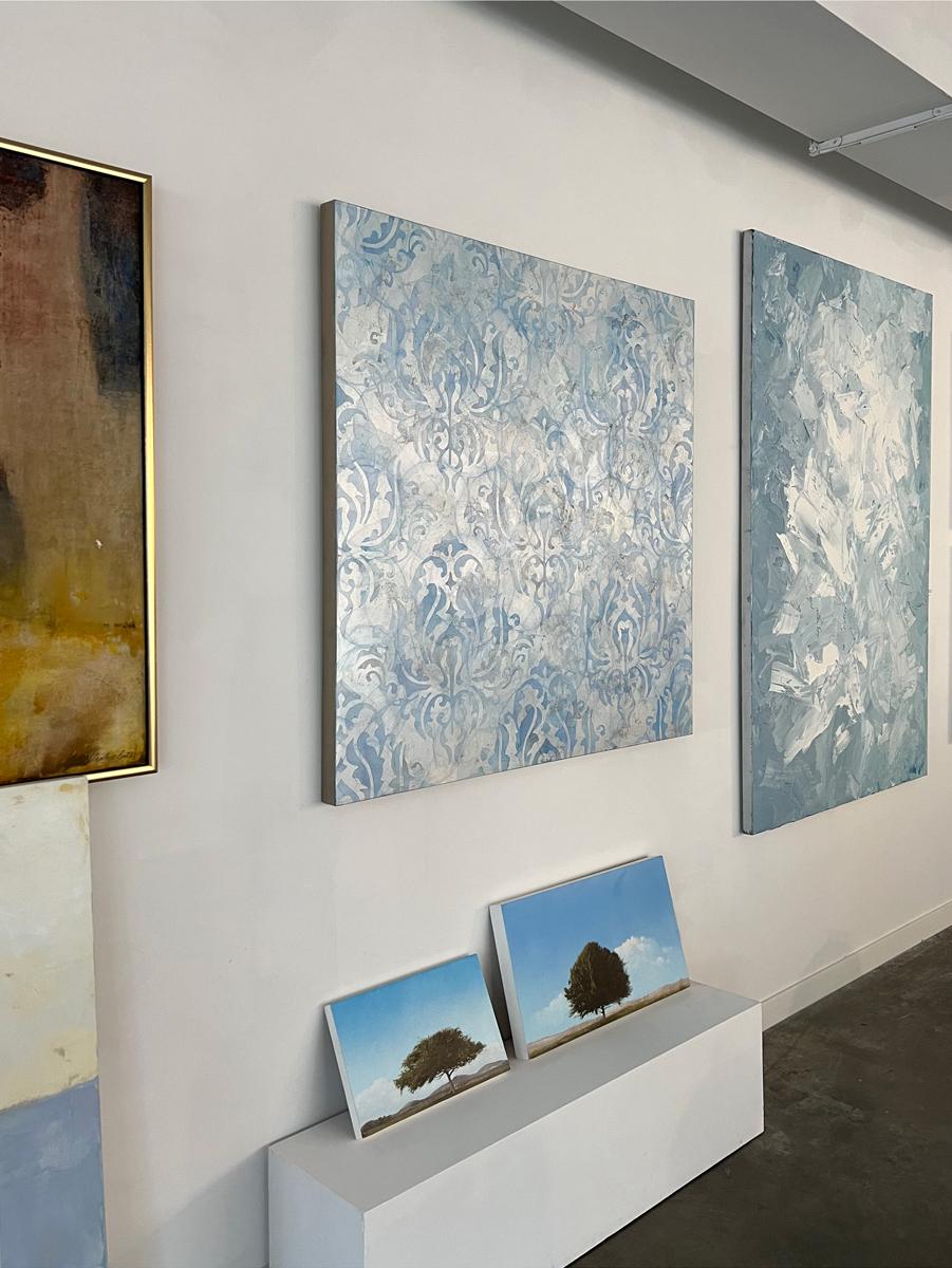 Questo quadro astratto di Roger Mudre è realizzato con pittura acrilica su foglia di metallo su pannello. L'opera è caratterizzata da una tavolozza di blu freddo e argento metallico e fa parte della serie Venezia di Mudre, ispirata al suo recente