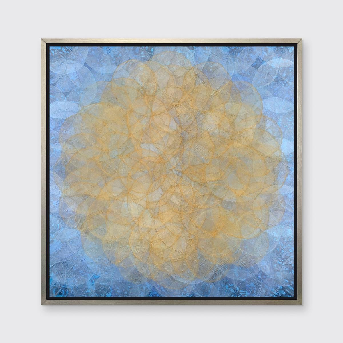 This abstract geometric limited edition print by Roger Mudre features lightly translucent concentric circles that overlap throughout the composition, creating a glowing effect of a yellow-gold circle at the center, surrounded by a light blue