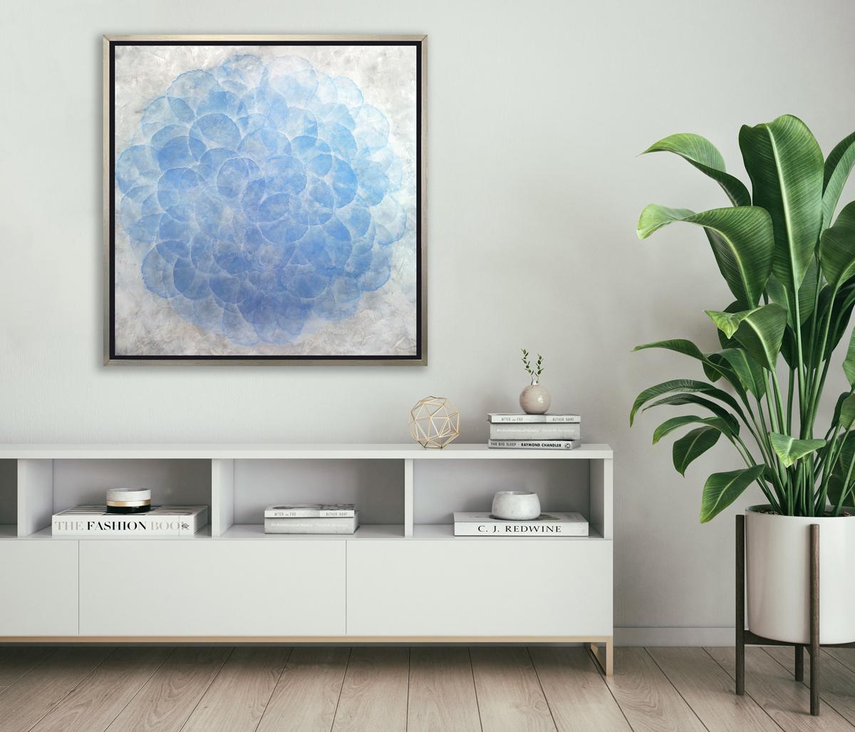 This Limited Edition giclee print by Roger Mudre features nearly transparent light blue circles, arranged in an overlapping pattern to create a larger circle shape. The outer layer of the circle blends into the surrounding silver-grey background and